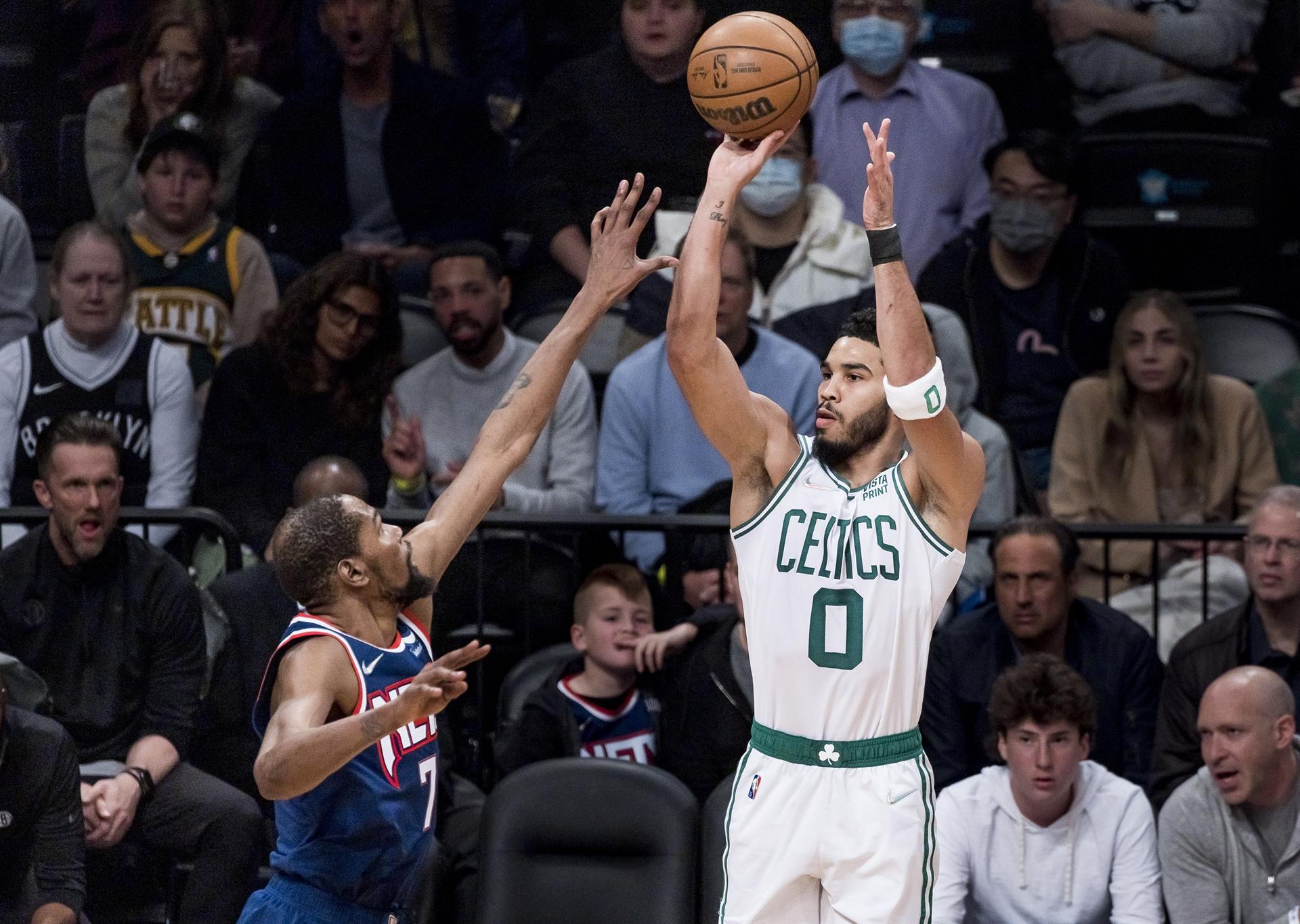 El jugador de los Celtics de Boston Jayson Tatum (d) lanza ante Kevin Durant (i), de los Nets de Brooklyn, el 25 de abril de 2022
