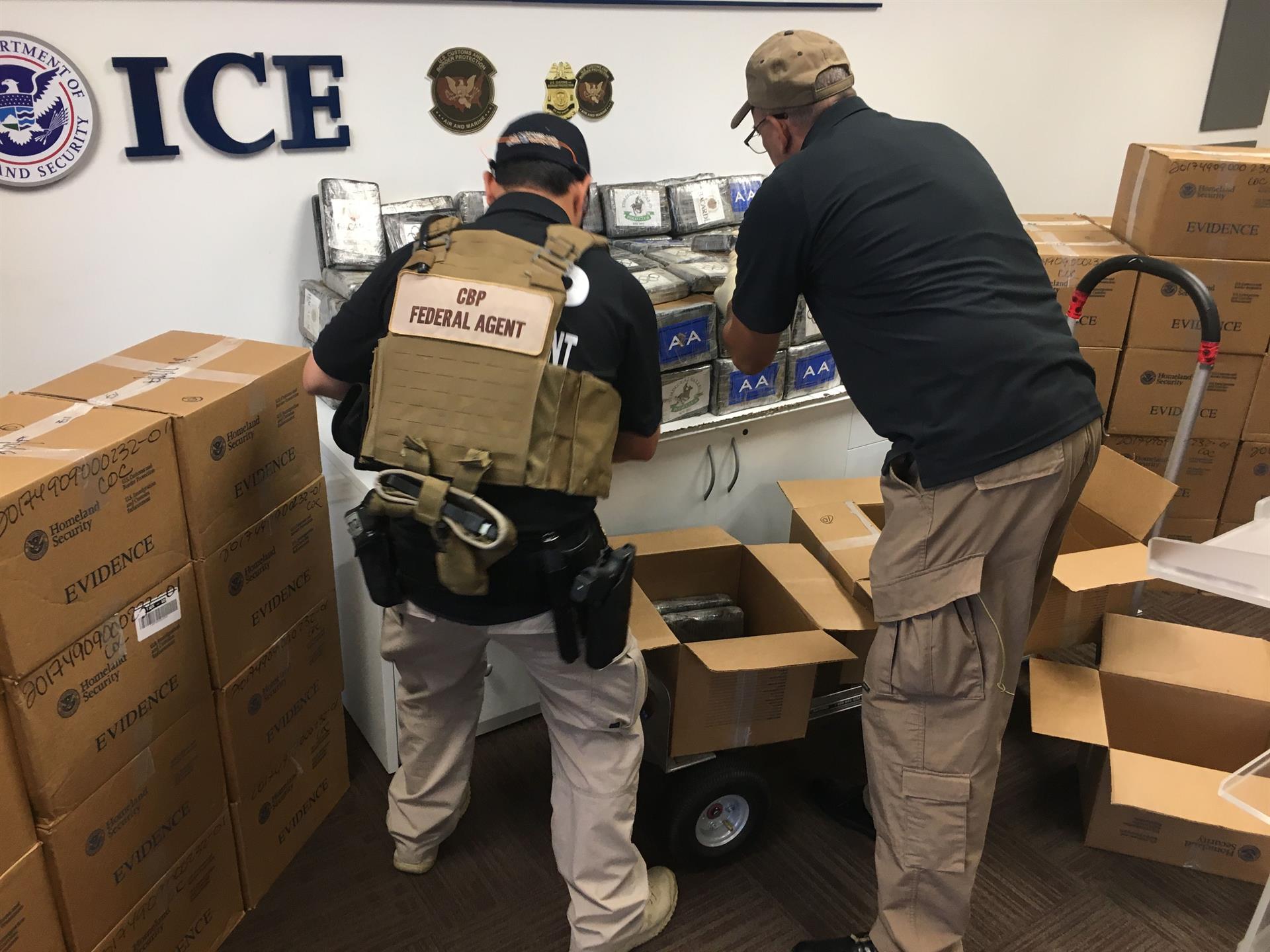 Dos funcionarios del Servicio de Aduanas y Fronteras de Estados Unidos colocan paquetes de cocaína decomisados a narcotraficantes en San Juan (Puerto Rico). EFE/Jorge Muñiz
