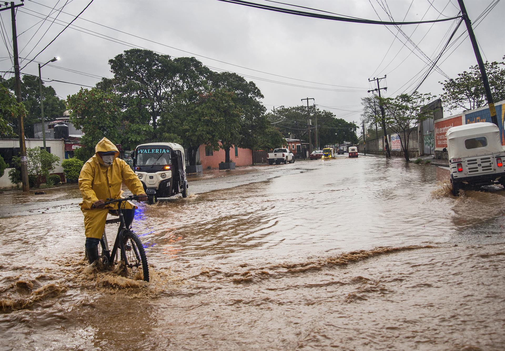 Personas transitan por una avenida inundada en el municipio de Tehuantepec, estado de Oaxaca (México). EFE/Luis Villalobos
