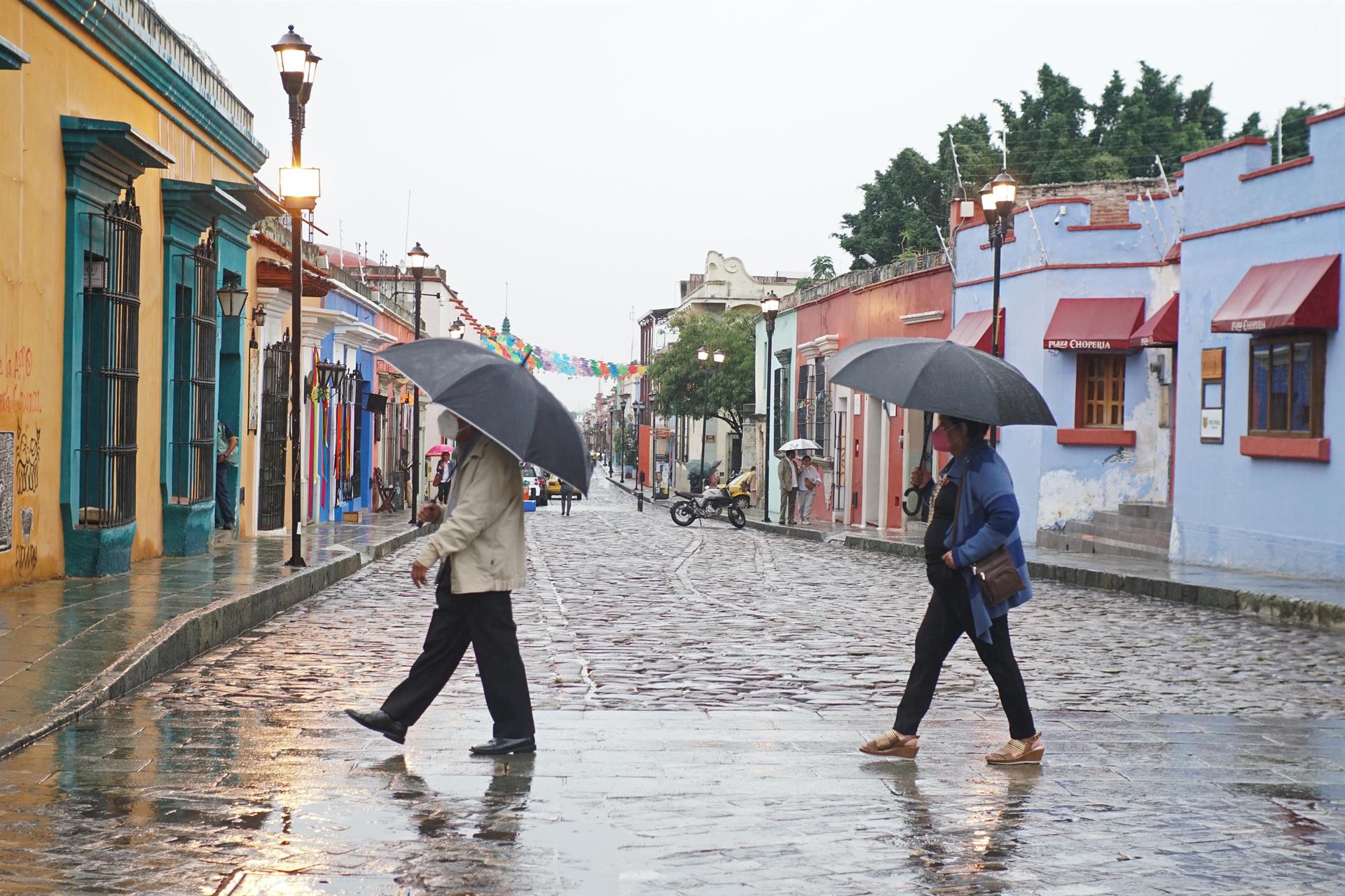 Dos personas  se protegen de la lluvia , en el estado de Oaxaca (México). E EFE/Daniel Ricardez
