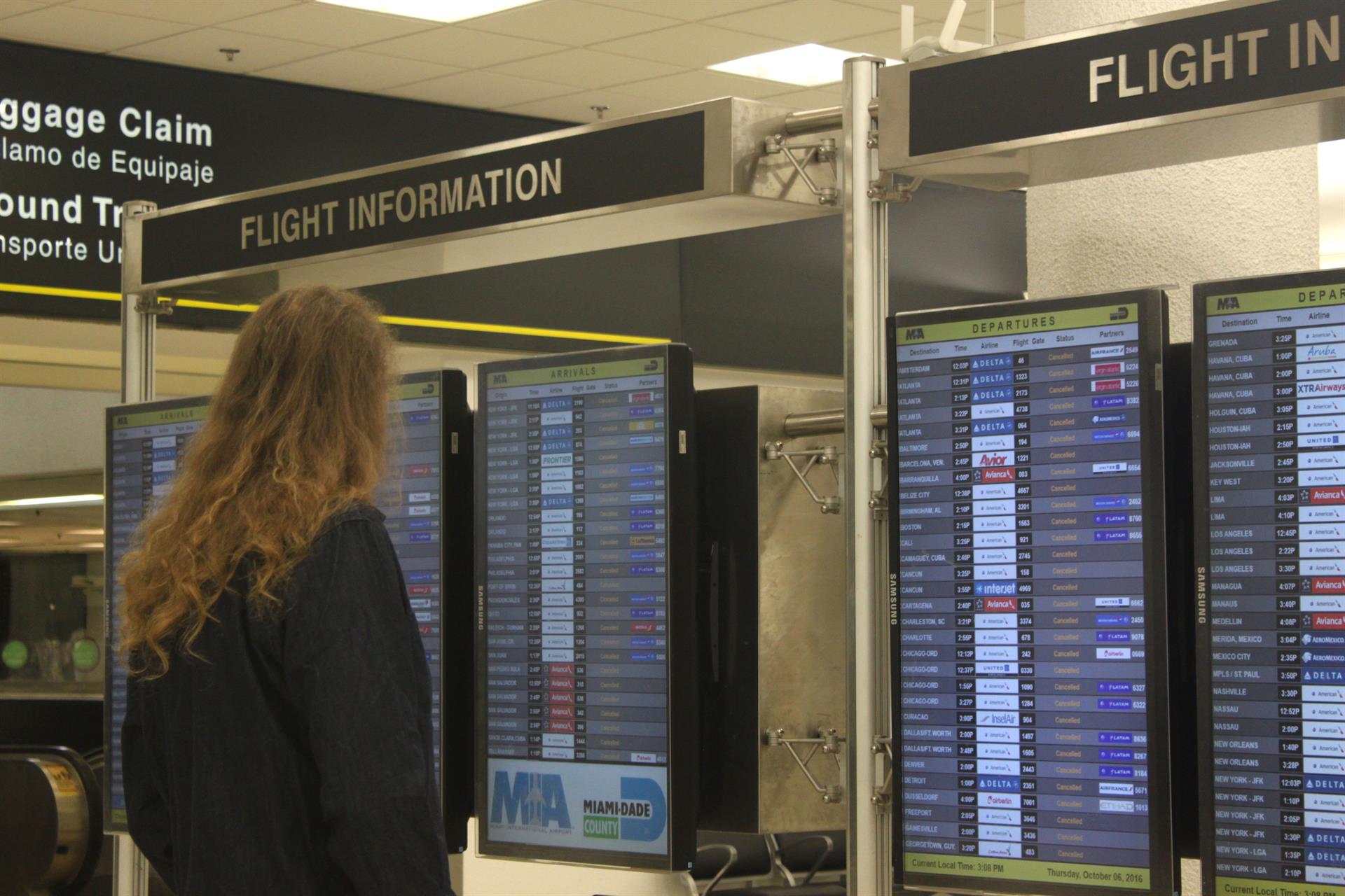 Una mujer observa el panel de salida y llegada de vuelos en un vacío aeropuerto de Miami (Florida), imagen de archivo. EFE/RODRIGO MIRAGAYA
