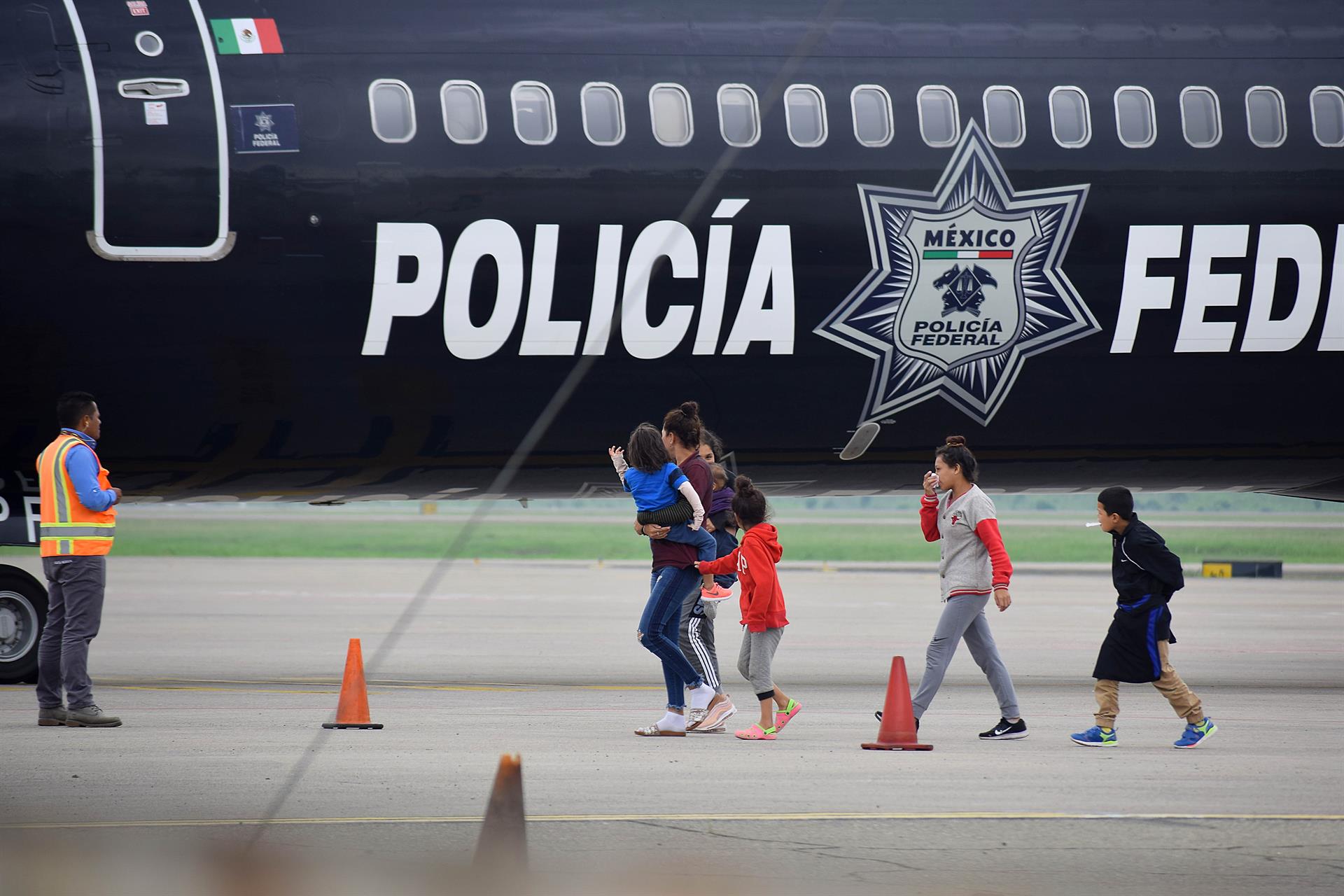 Fotografía de archivo de un grupo de migrantes hondureños que hacía parte de la caravana rumbo a EE.UU. llega en un avión de la policía mexicana al aeropuerto Ramón Villeda Morales, cerca de San Pedro Sula (Honduras). EFE/ José Valle
