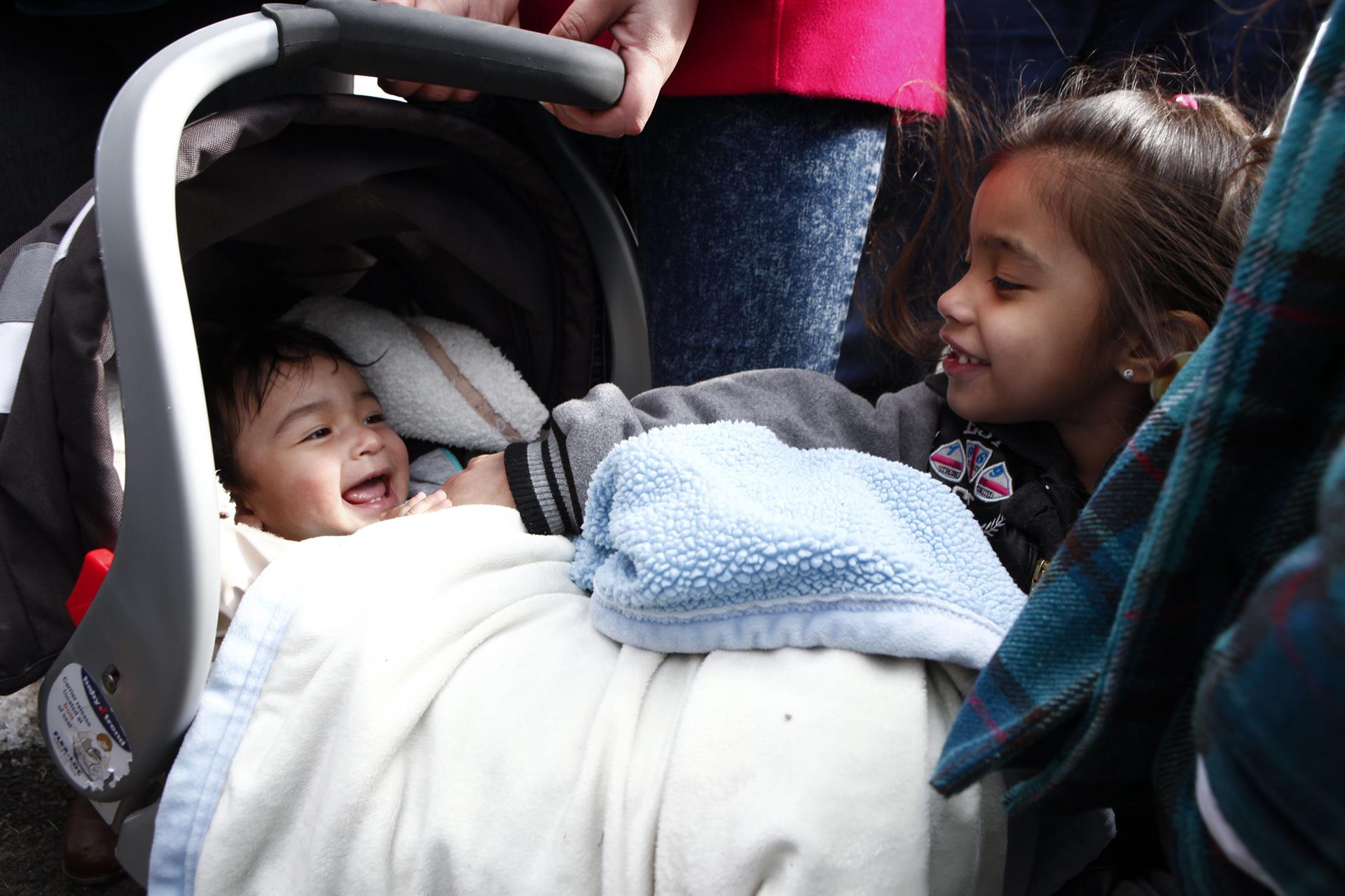 Vista de un bebé que sonríe junto a su hermana pequeña. Imagen de archivo. EFE/ Kena Betancur
