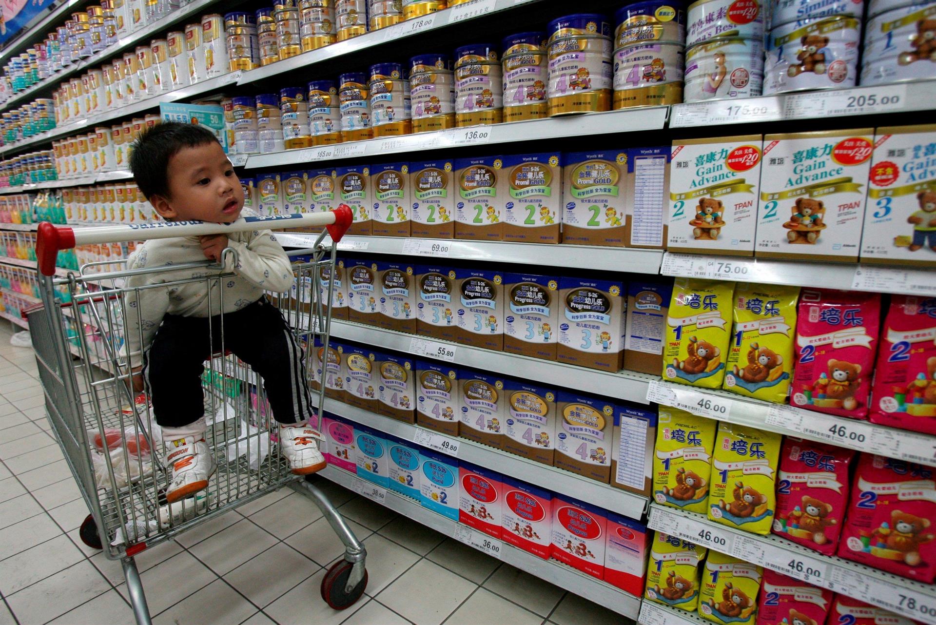 Fotografía de archivo de un bebé que espera a su madre sentado en un carrito de la compra en el pasillo de productos lácteos de un supermercado. EFE/D.Wong
