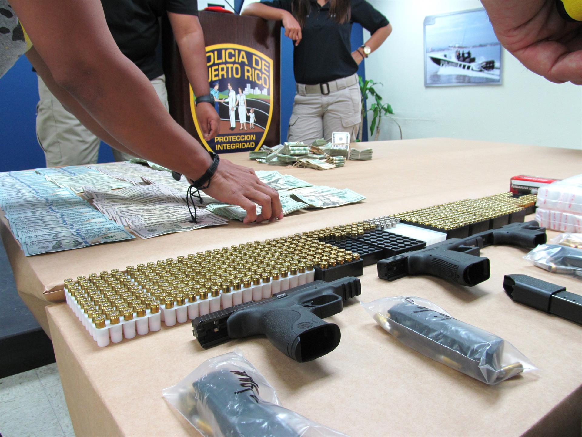 Imagen de archivo que muestra el detalle de algunas armas, dinero y drogas incautadas por la Policía de Puerto rico. EFE/Jorge Muñiz
