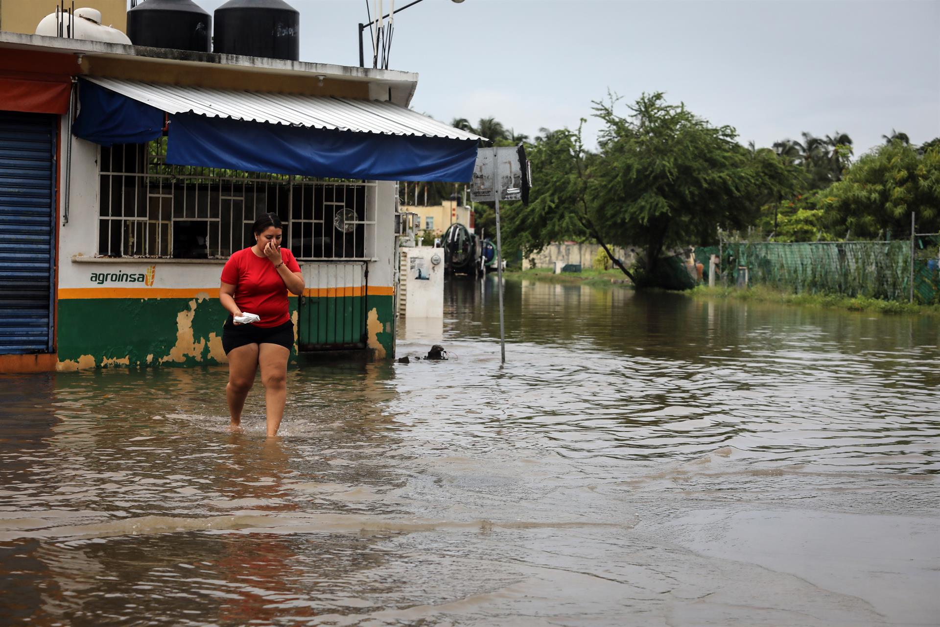 Una mujer camina por una calle inundada debido a las fuertes lluvias hoy, en Acapulco, estado de Guerrero (México). EFE/ David Guzmán
