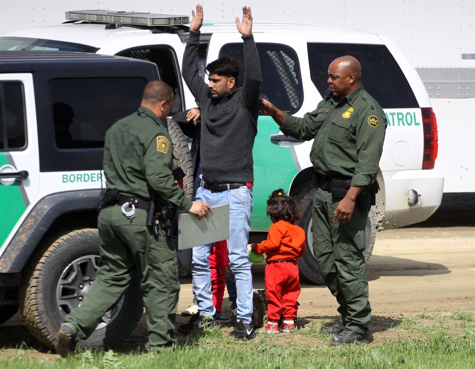 Agentes migratorios estadounidenses interceptan a un hombre junto a su esposa e hijas tras ingresar a territorio norteamericano por la valla fronteriza que separa México de Estados Unidos. EFE/Alejandro Zepeda
