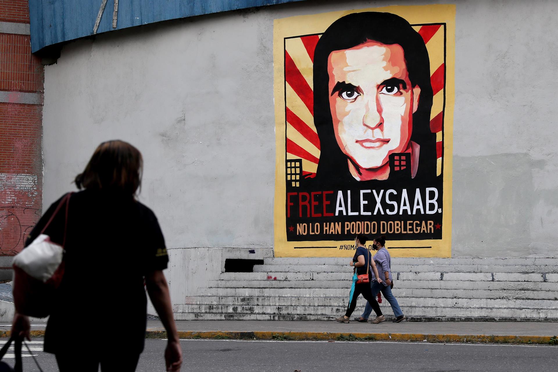 Personas pasan frente a un cartel de apoyo al empresario colombo-venezolano Alex Saab, en Caracas (Venezuela), imagen de archivo. EFE/ Miguel Gutiérrez
