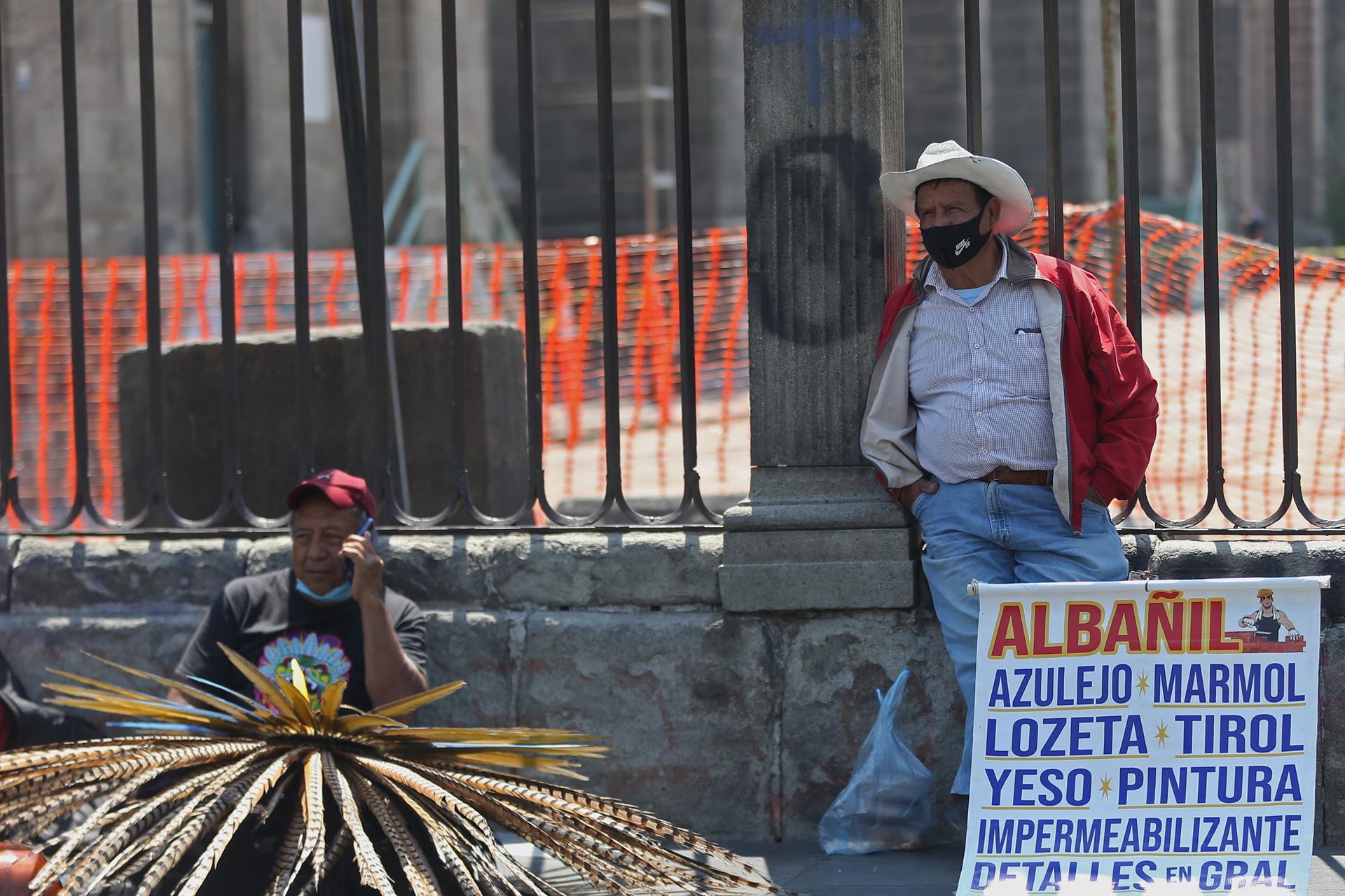 Dos hombres ofrecen sus servicios de trabajo en las rejas de la Catedral Metropolitana, en Ciudad de México (México). Imagen de archivo. EFE/ Sáshenka Gutiérrez
