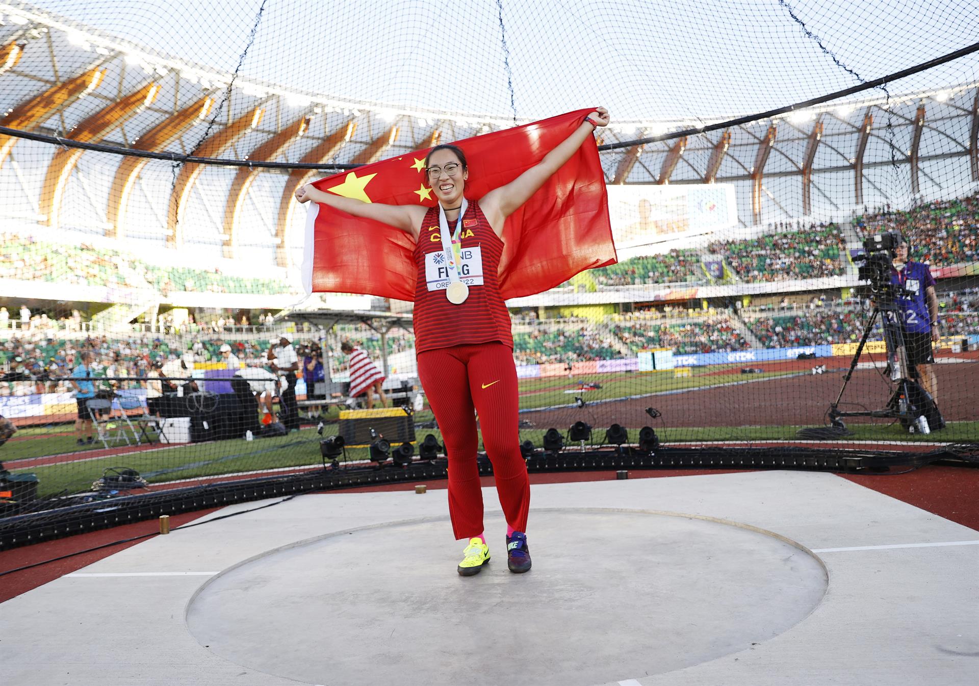 La medallista de oro Bin Feng de China posa para fotos con su medalla y bandera nacional después de la final de lanzamiento de disco femenino, durante el Campeonato Mundial de Atletismo Oregon, en Hayward Field, Estados Unidos. EFE/EPA/Robert Ghement
