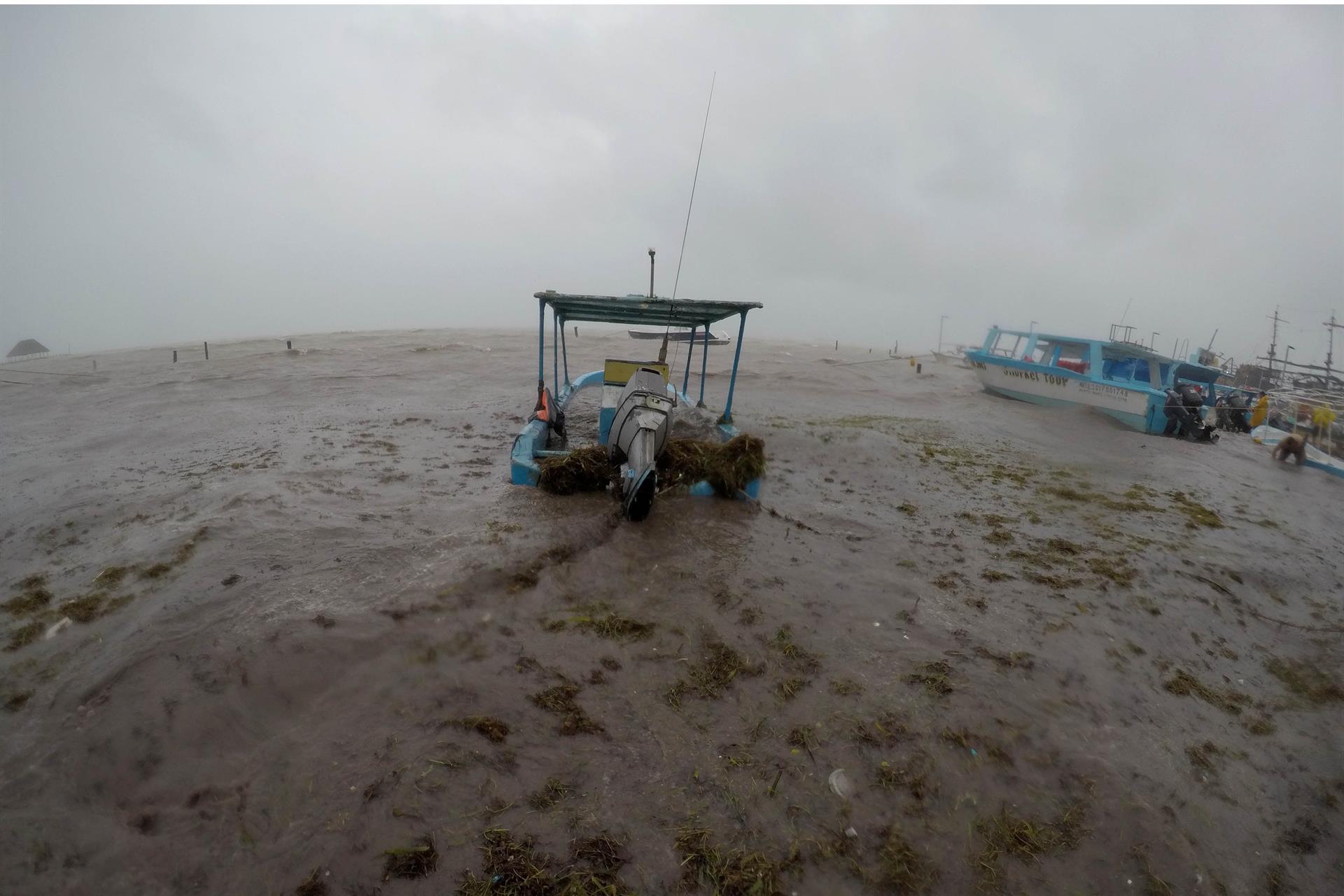Fotografía de archivo de pescadores que aseguran sus barcas debido al paso de una tormenta tropical. EFE/ Alonso Cupul
