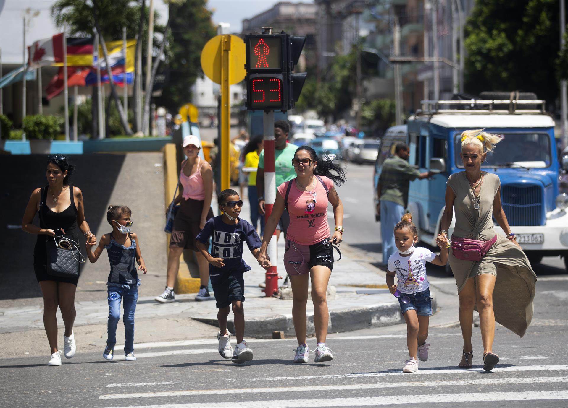 Varias madres con sus hijos son vistas cruzando una calleen La Habana (Cuba). EFE/Yander Zamora
