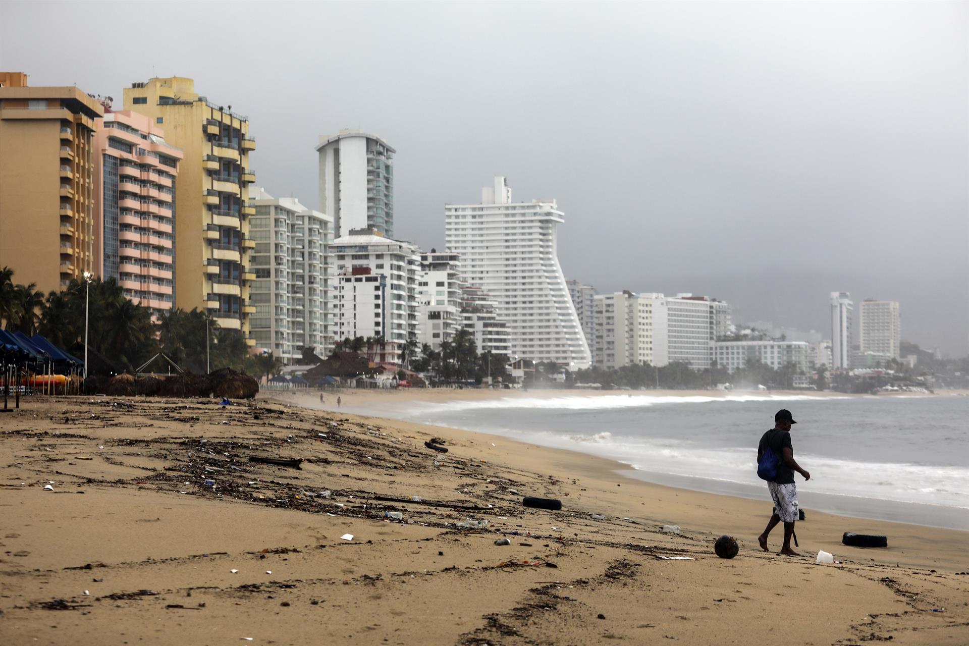 Una persona camina por una playa llena de basura debido a las fuertes lluvias en Acapulco, estado de Guerrero (México). Imagen de archivo. EFE/ David Guzmán
