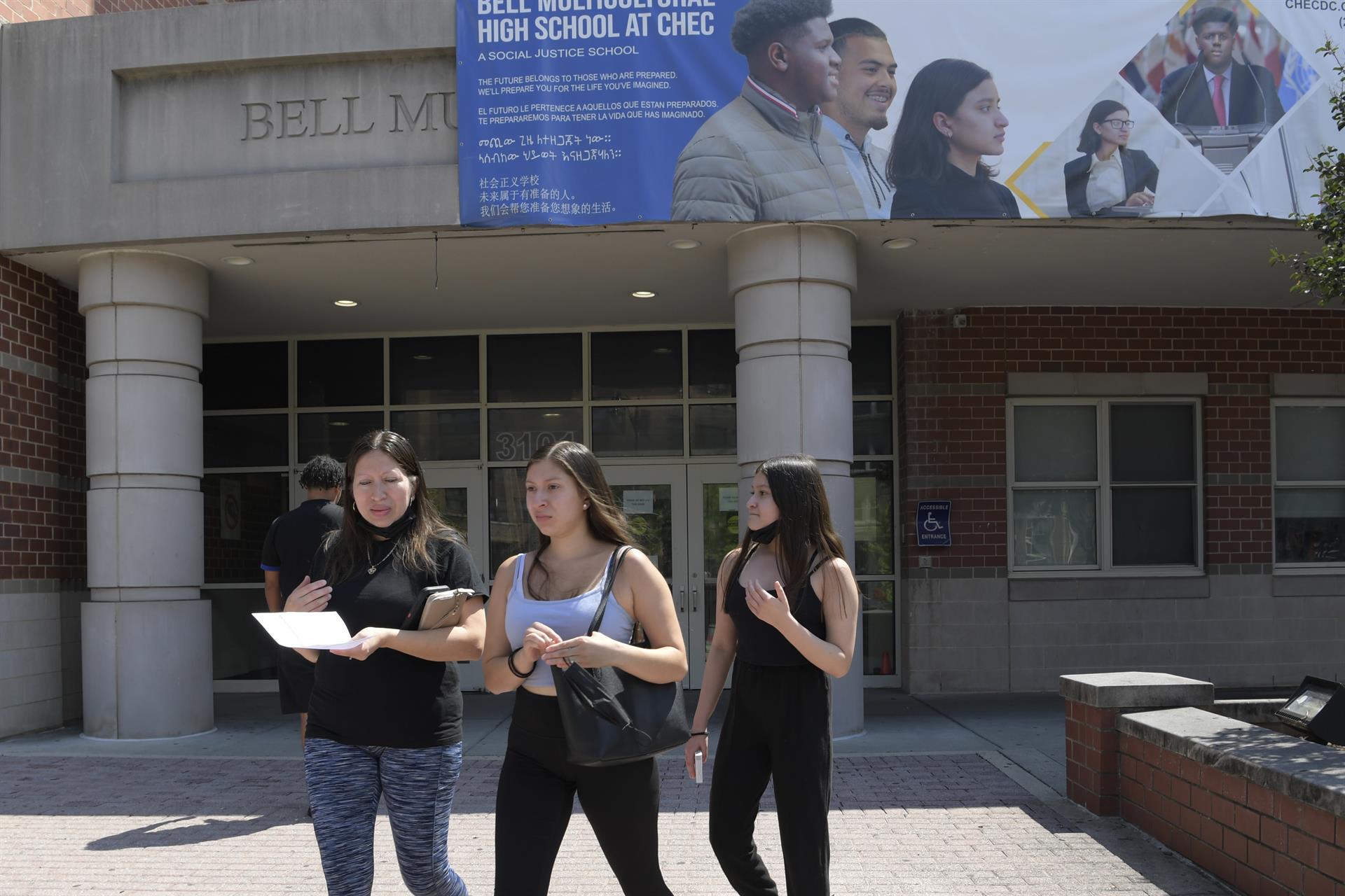 Una mujer y sus hijas salen de la Escuela Multicultural Secundaria Bell durante el primer día de clases, el 26 de agosto de 2022, en Washington (Estados Unidos). EFE/ Lenin Nolly
