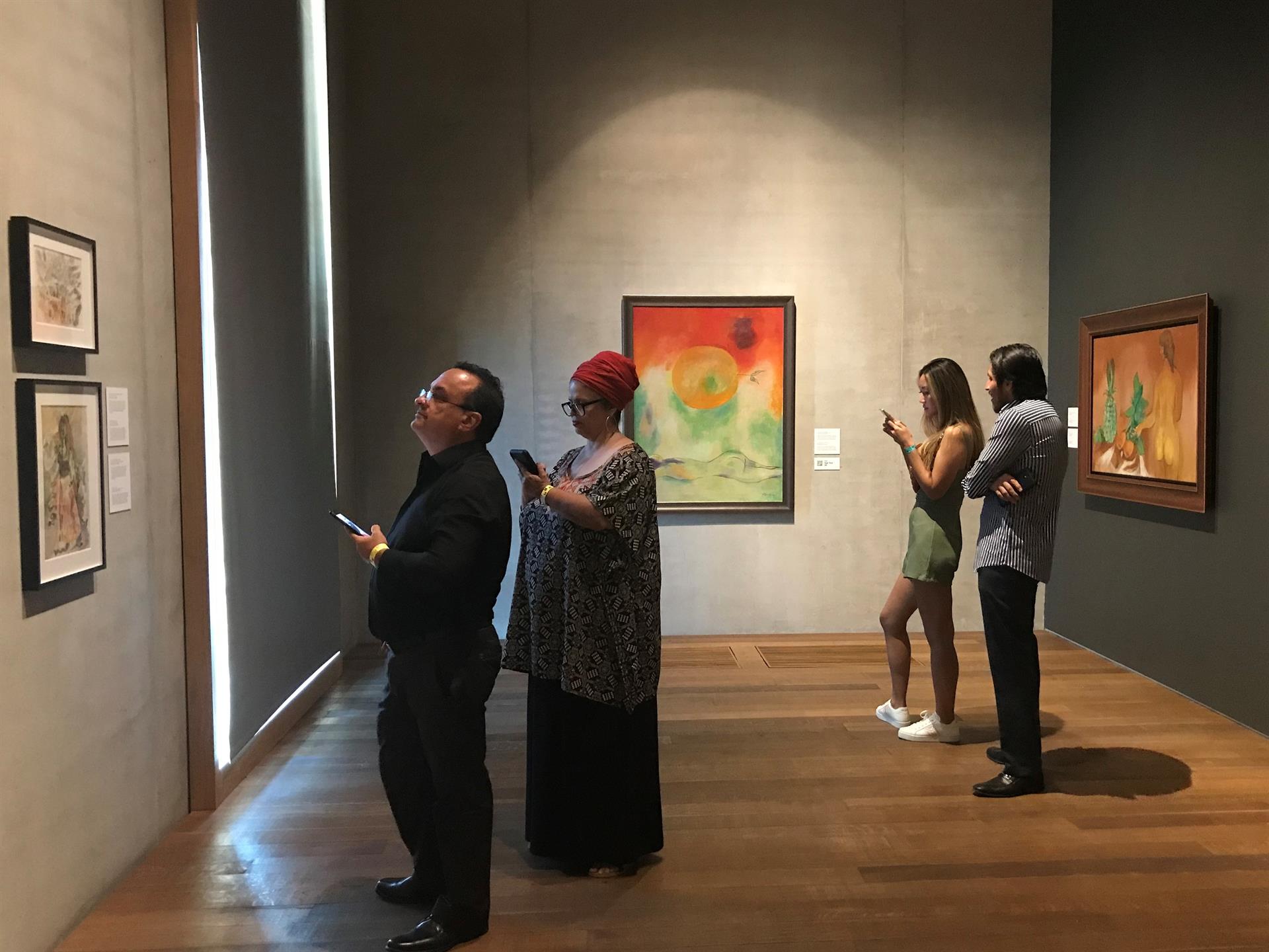 Visitantes observan las obras del pintor cubano Mariano Rodríguez durante la exposición 