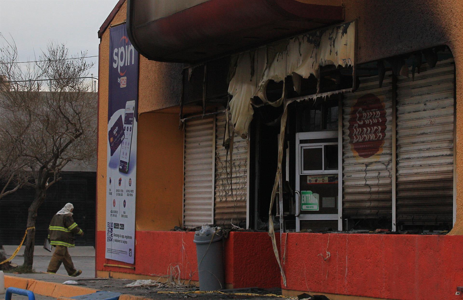 Bomberos trabajan en una tienda que fue incendiada por personas armadas hoy en Ciudad Juárez, estado de Chihuahua (México). EFE/Luis Torres
