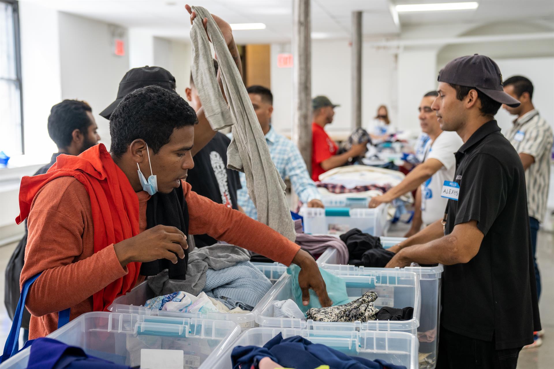 Migrantes buscan prendas de vestir donadas a la organización AID For Life Internacional, en la iglesia de Santa Teresa hoy en Nueva York (EE. UU). EFE/ Ángel Colmenares
