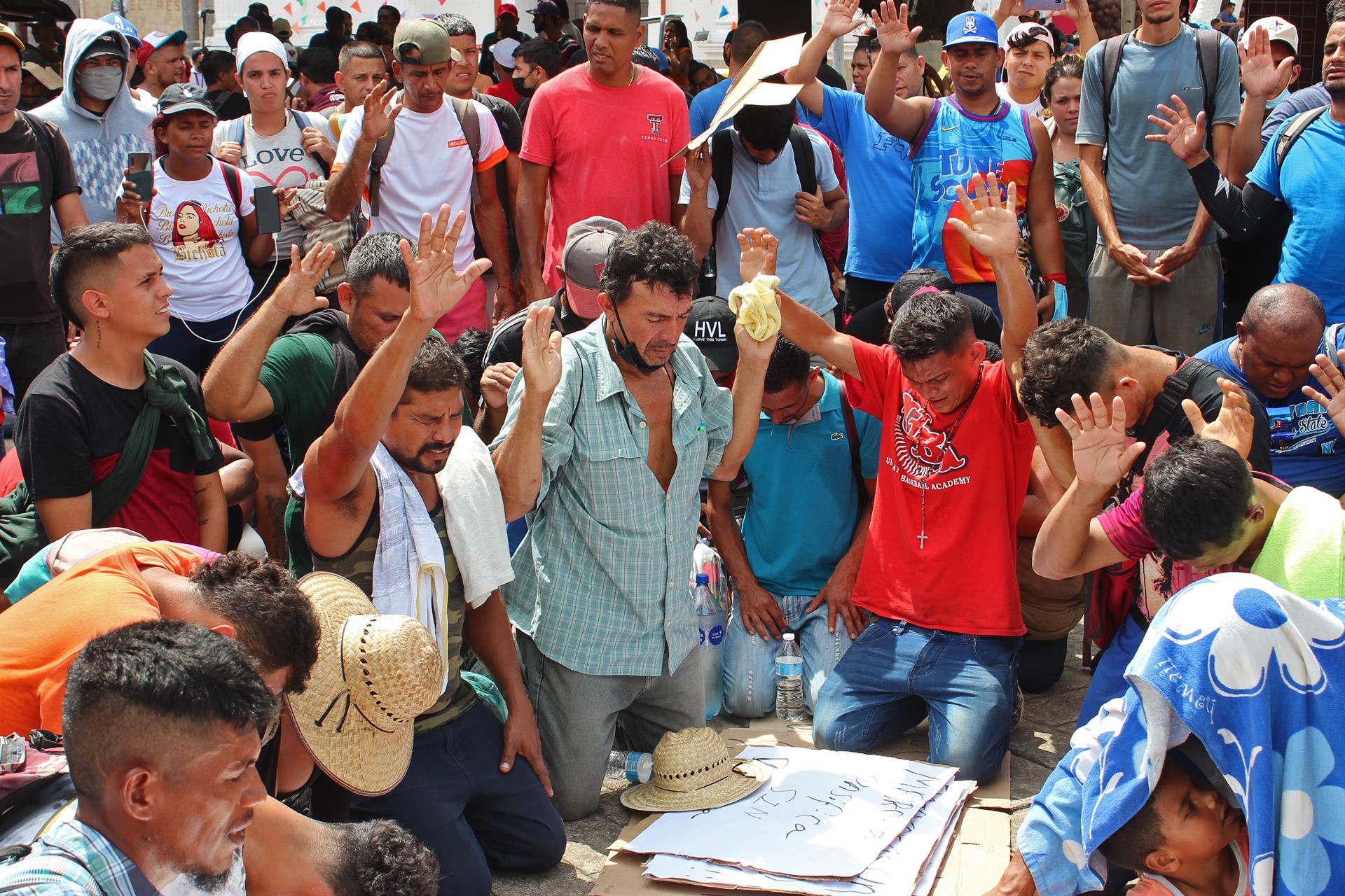 Grupos de personas migrantes rezan en un descanso hoy, en la ciudad de Tapachula, en el estado de Chiapas (México). EFE/ Juan Manuel Blanco
