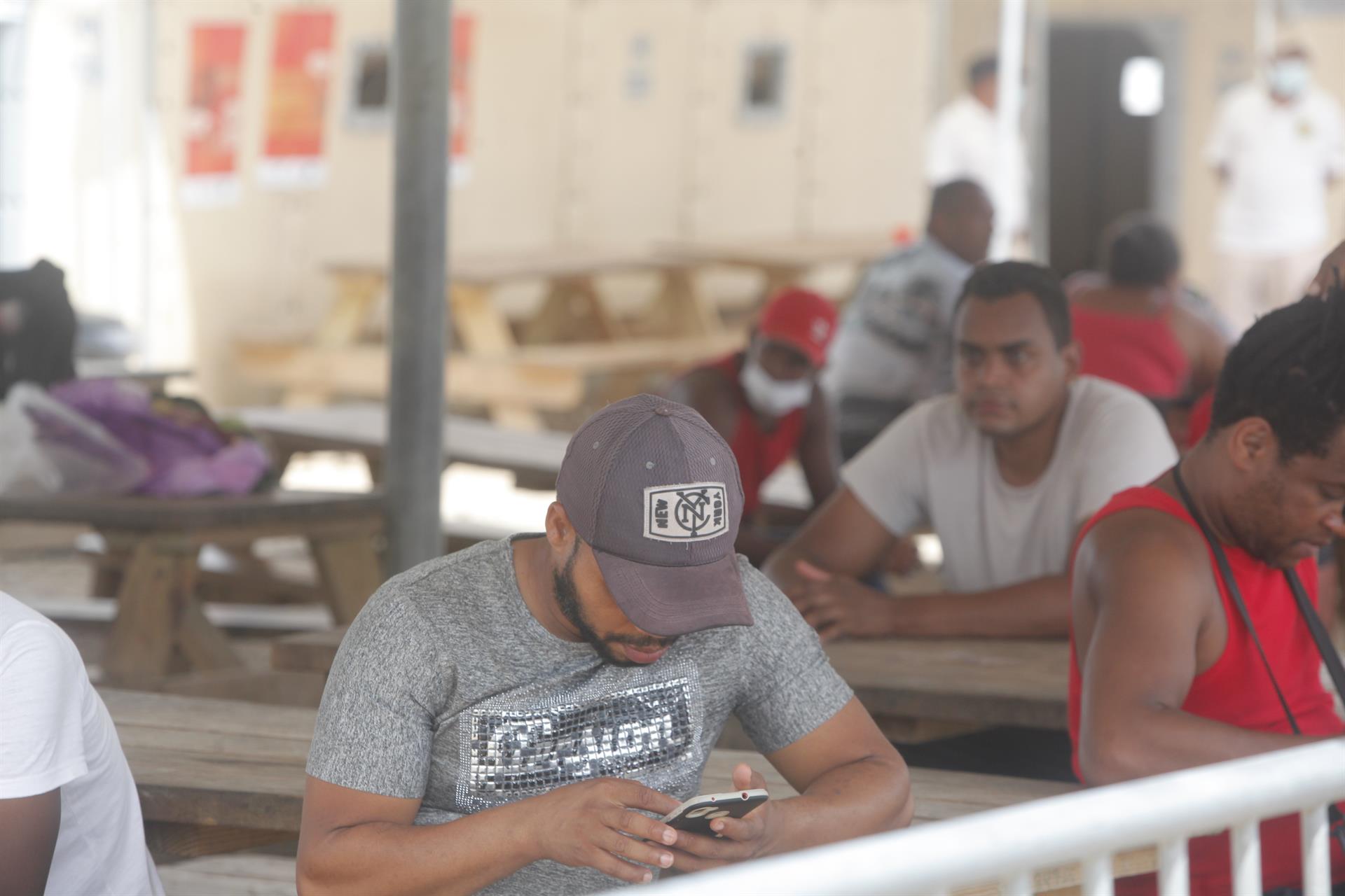 Un hombre es visto usando su celular en un campamento de migrantes procedentes de diversos países en Darién (Panamá). Imagen de archivo. EFE/ Carlos Lemos
