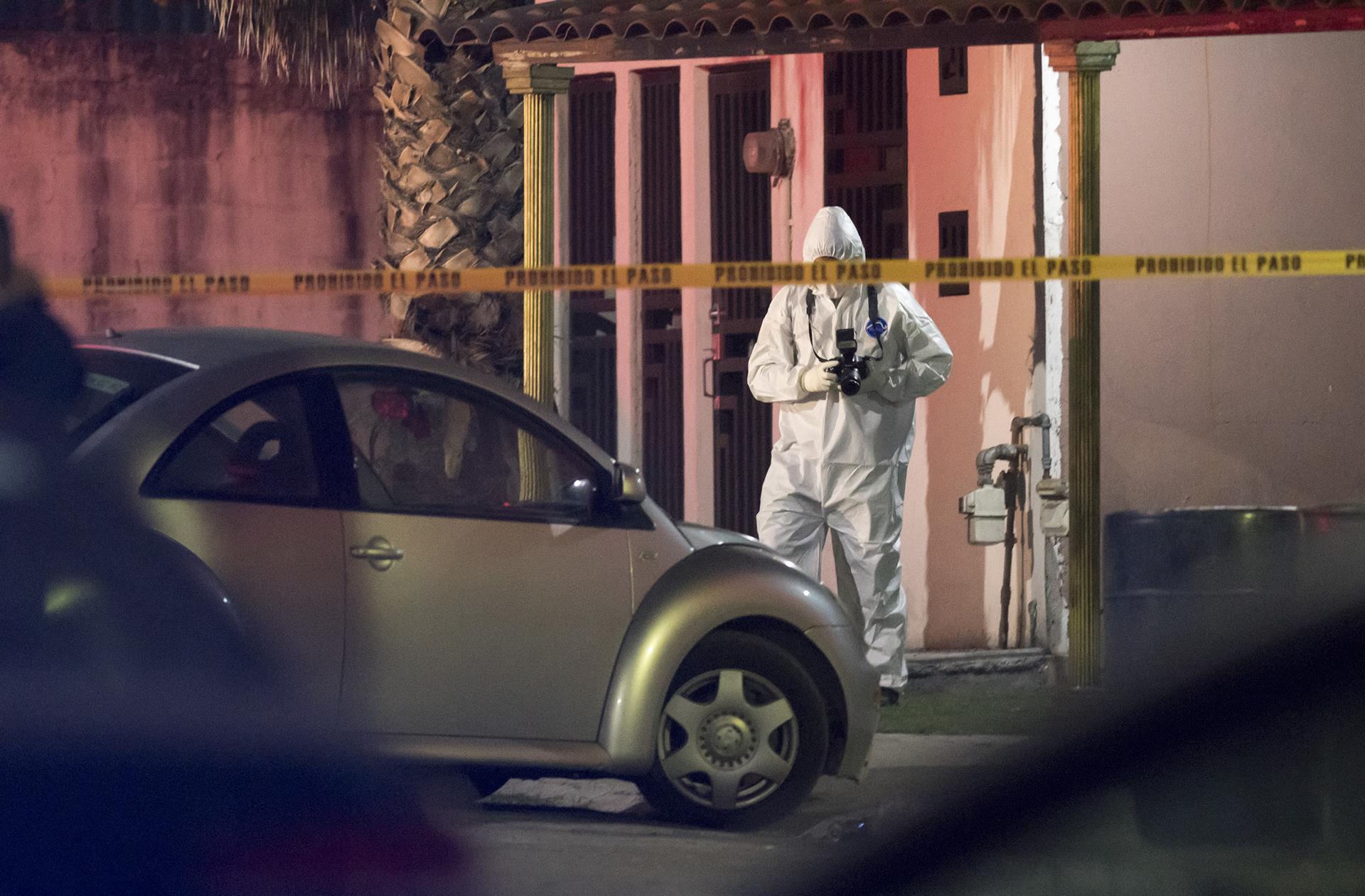 Fotografía de archivo de peritos forenses que inspeccionan la zona donde ocurrió un ataque armado. EFE/Miguel Sierra
