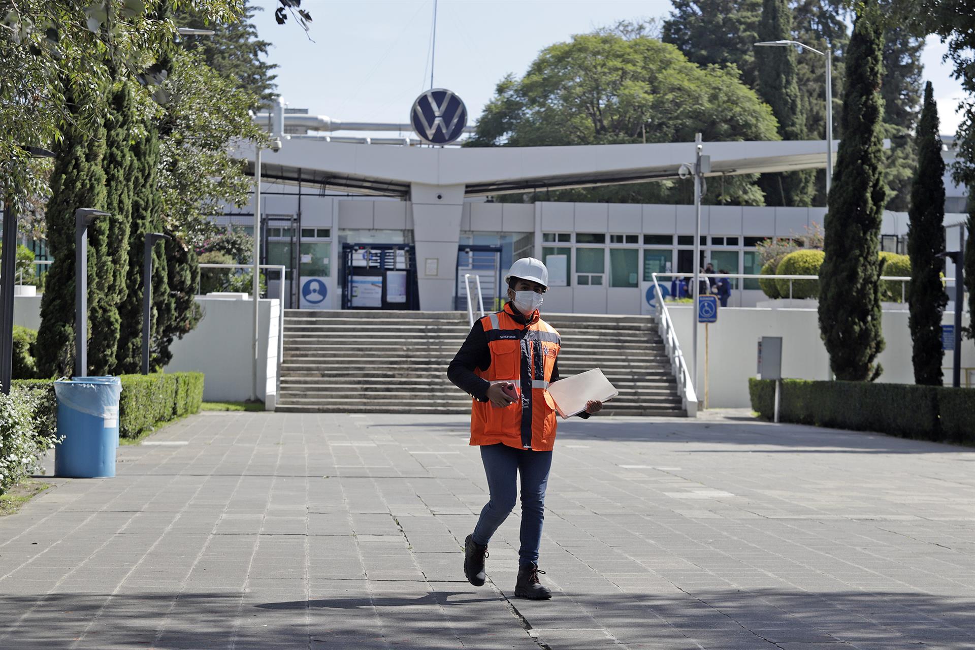 Una persona camina frente a la fachada de la planta armadora Volkswagen, hoy en el estado de Puebla (México). EFE/Hilda Ríos
