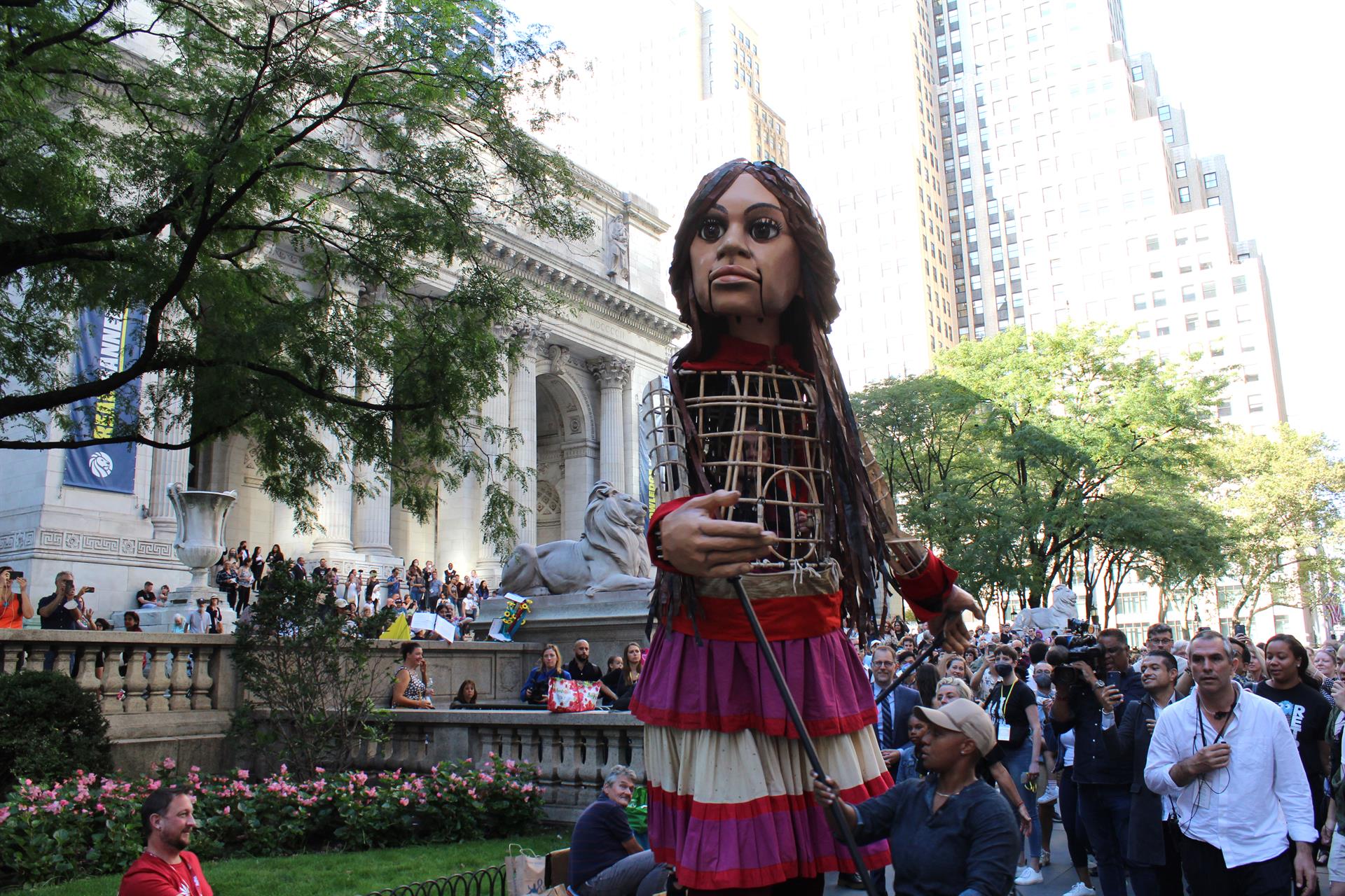 Cientos de personas reciben a la marioneta Amal, que en árabe significa esperanza, durante su marcha por las calles en el marco de la iniciativa 