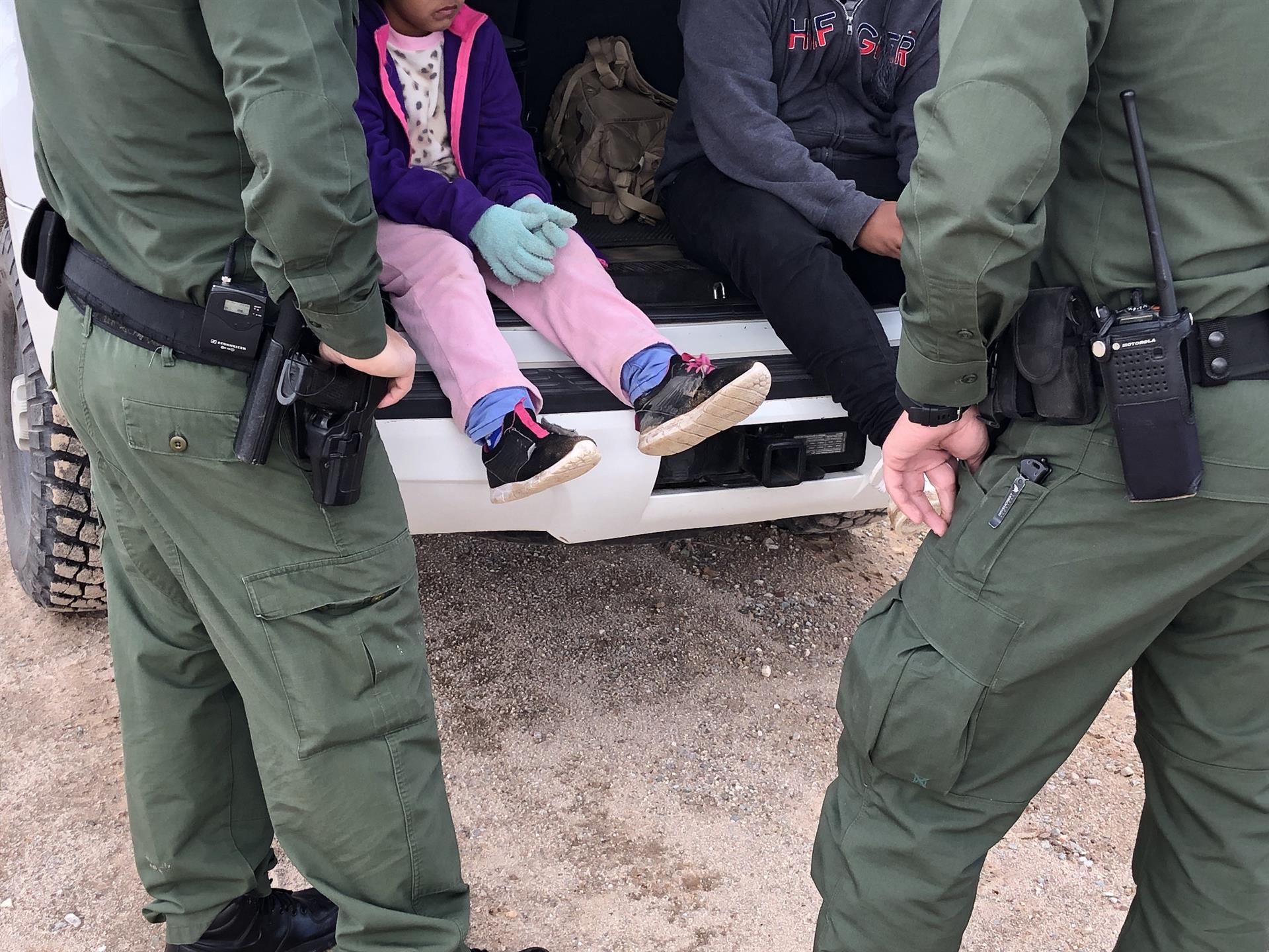 Fotografía de archivo donde aparecen dos agentes de la Patrulla Fronteriza mientras atienden a unos niños en un punto del área conocido como Quitobaquito, en la frontera de Arizona con México (EE.UU.). EFE/Paula Díaz
