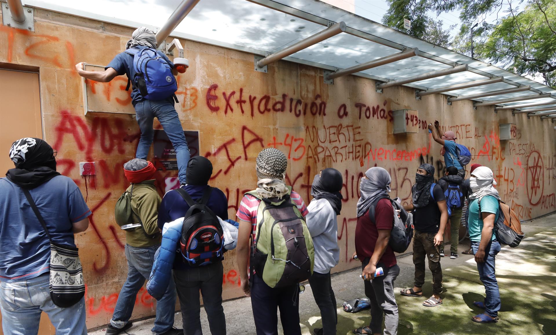 Activistas y familiares de los estudiantes desaparecidos de Ayotzinapa, vandalizaron este miércoles al exterior de la Embajada de Israel, en la Ciudad de México (México). EFE/Mario Guzmán
