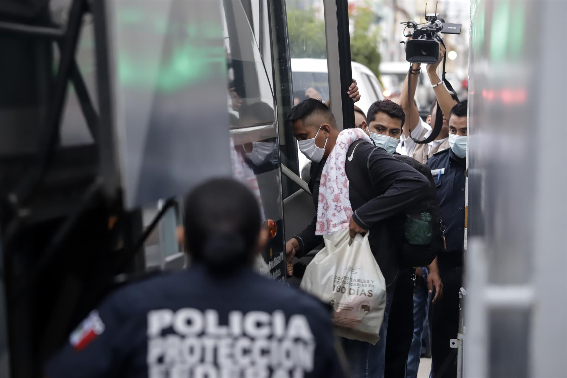 Personas migrantes suben a un autobús de pasajeros hoy, tras ser detenidos por personal del Instituto Nacional de Migración (INM) sobre la autopista en el estado de Puebla (México). EFE/ Hilda Ríos
