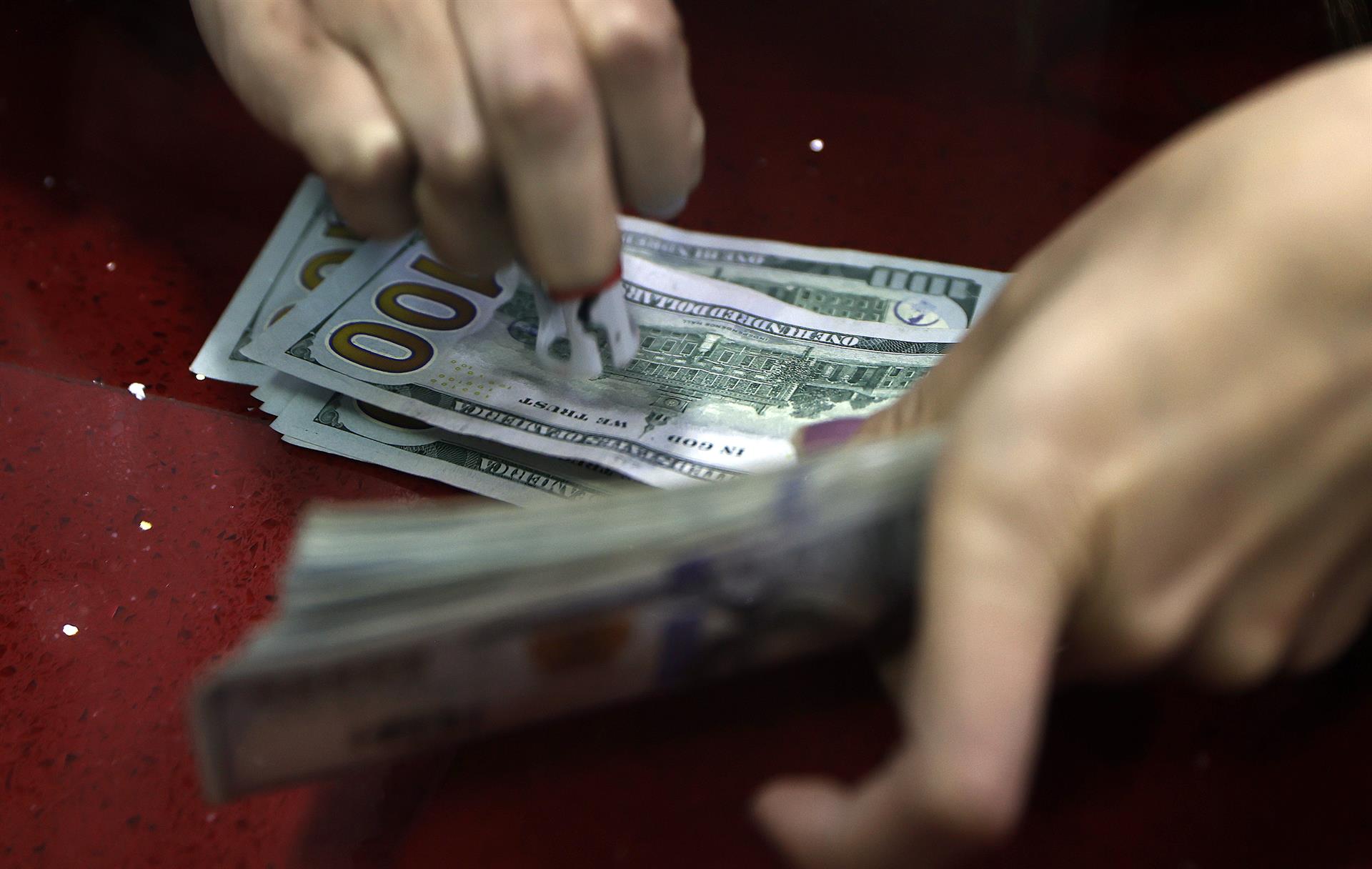 Fotografía de archivo que muestra a una persona contando billetes de cien dólares. EFE/ Mauricio Dueñas Castañeda

