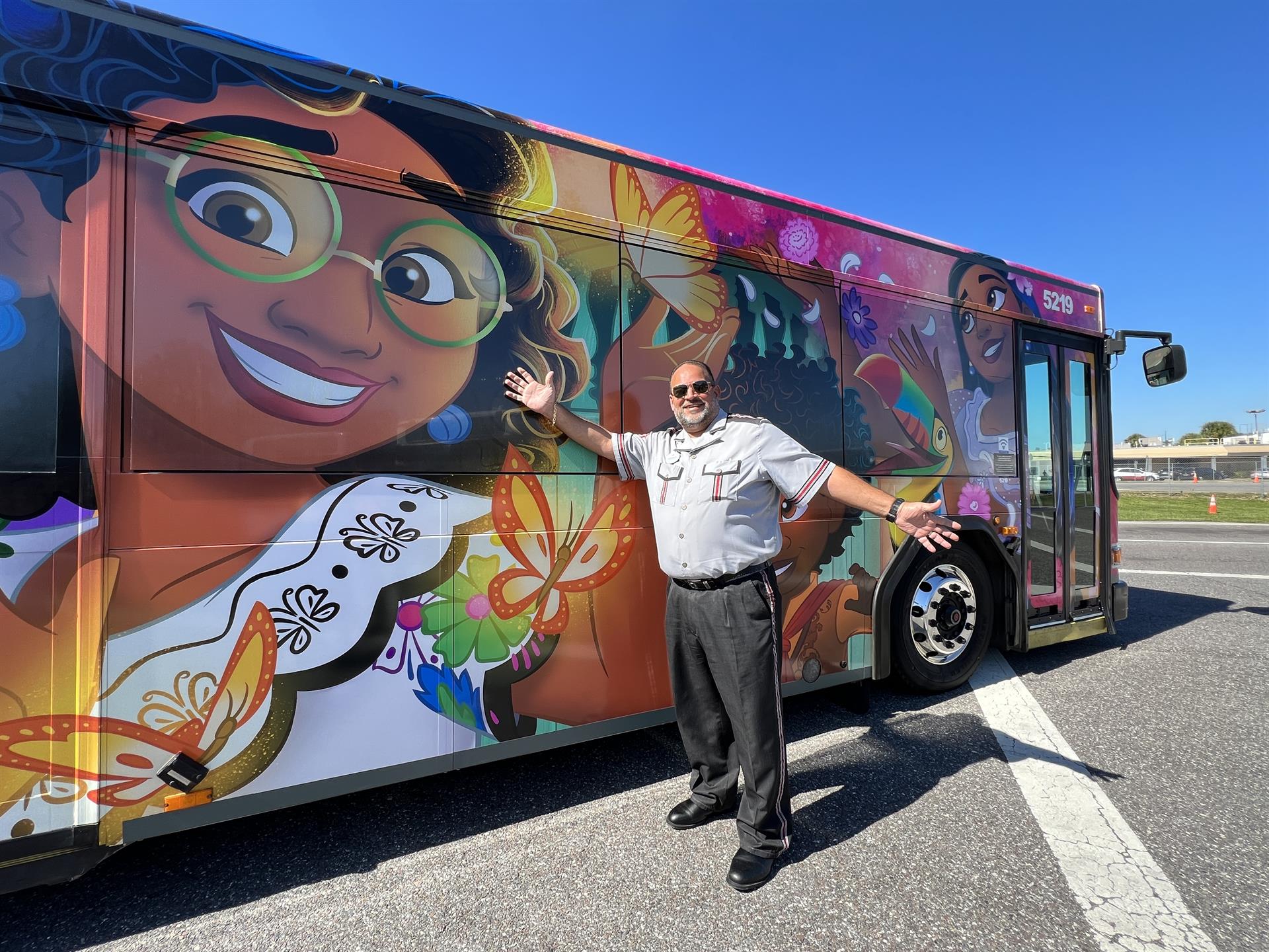 Fotografía cedida por Disney donde se muestra a un conductor mientras señala a un autobús decorado con personajes de la película 