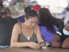 Una mujer es vista usando su celular en un campamento de migrantes procedentes de diversos países en Darién (Panamá). EFE/ Carlos Lemos
