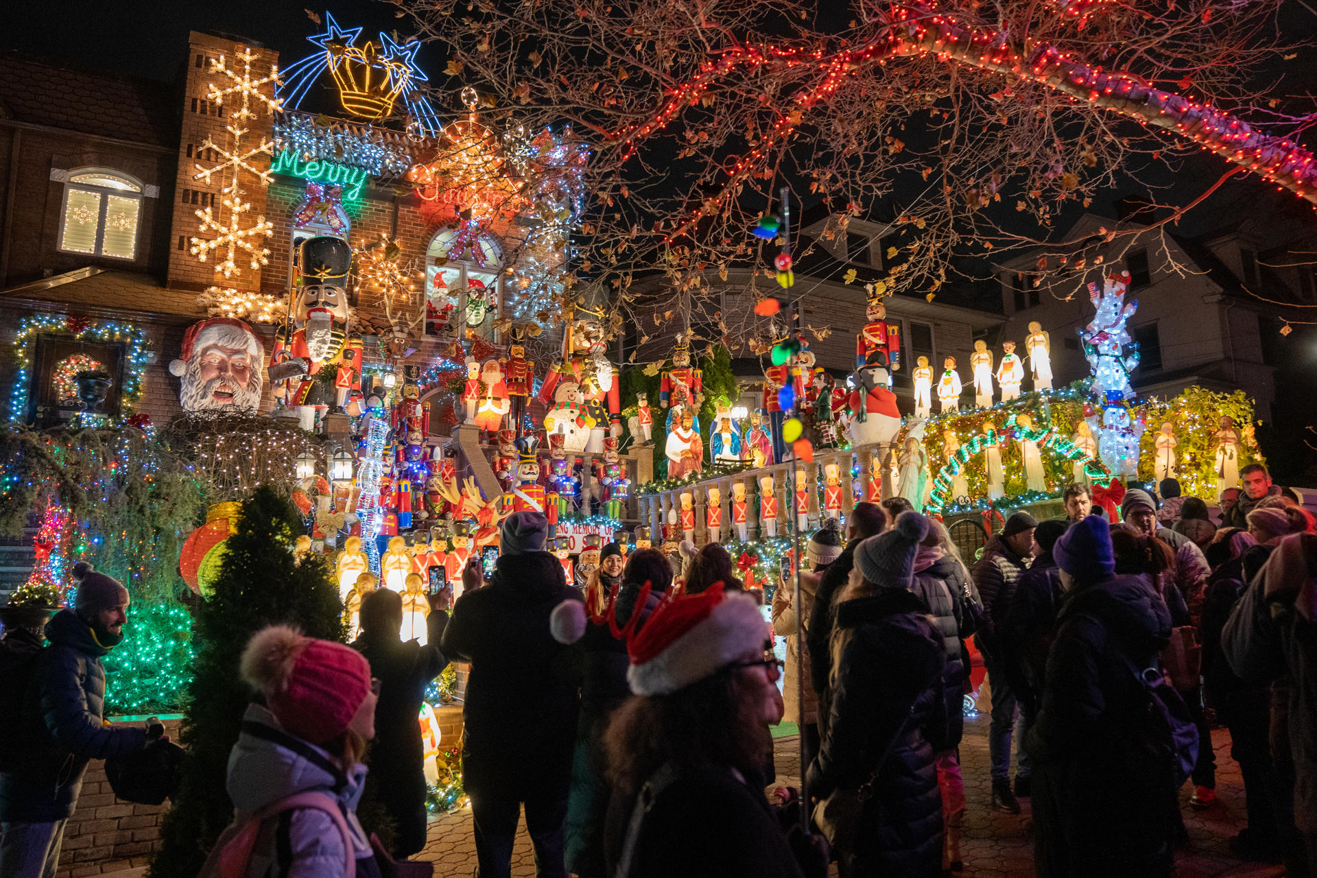 Personas visitan decoraciones navideñas puestas en las entradas de casas, el 8 de diciembre de 2022 en el barrio residencial de Dyker Heights, al sur de Brooklyn, Nueva York (EE. UU). EFE/Ángel Colmenares
