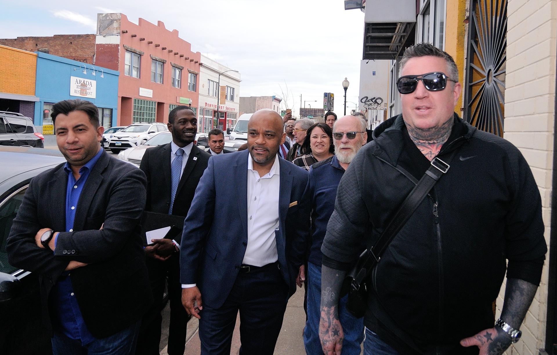 El alcalde de Denver Michael Hancock (c) camina junto al concejal de la ciudad Paul López (izq.) y el dueño de Tribe Tattoo, John Slaughter, durante su visita en Denver, Colorado. Imagen de archivo. EFE/Miguel Castro
