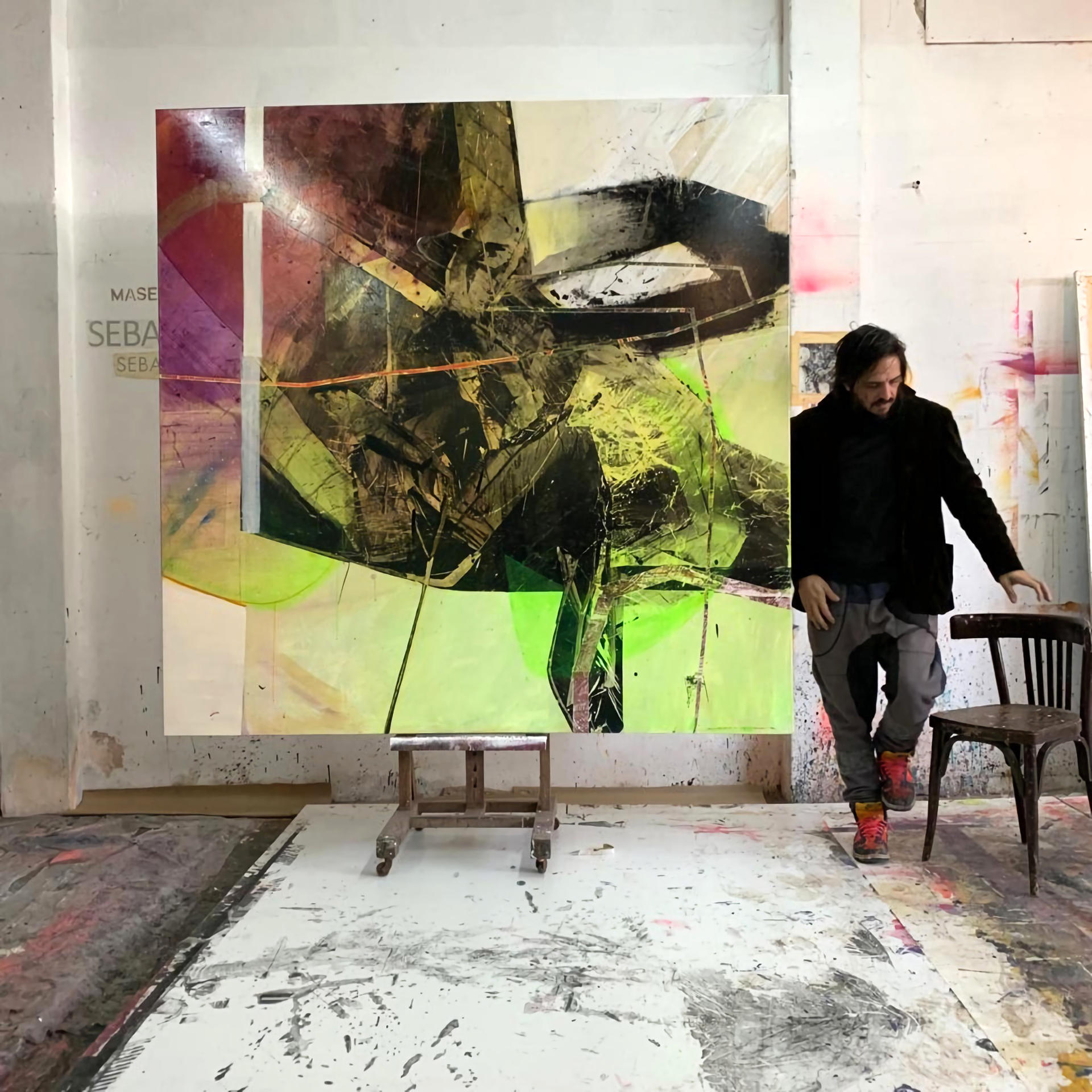 Fotografía personal cedida donde aparece el artista visual argentino Sebastián Masegosa junto a la obra que fue adquirida por Unicoin y que forma parte de su serie 