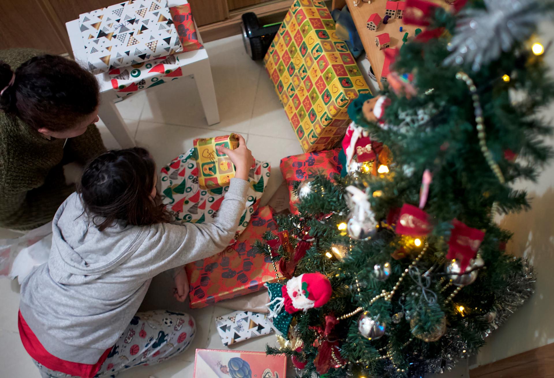Una familia abre los regalos junto al árbol de Navidad. Imagen de archivo. EFE/ Eliseo Trigo

