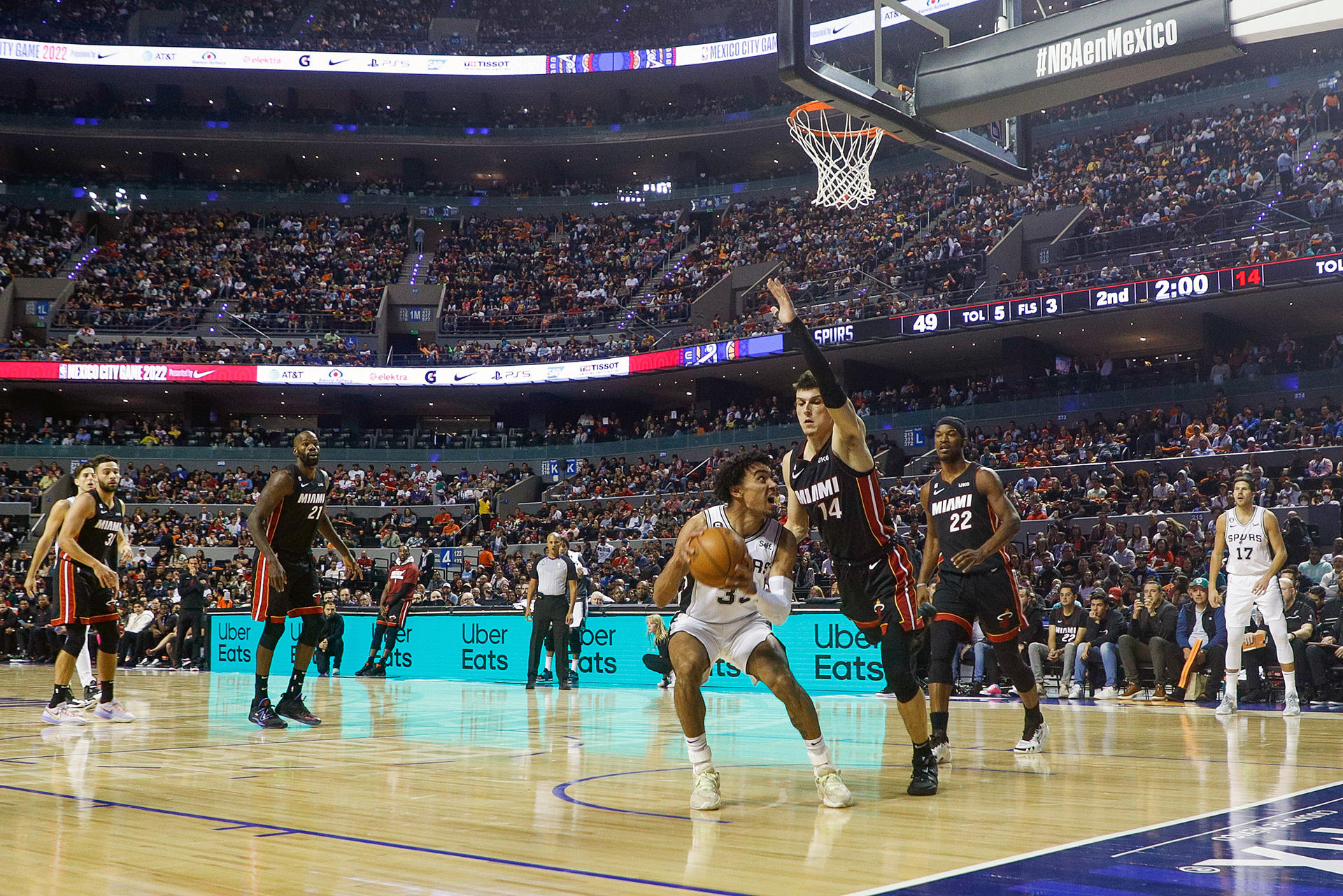 Tre Jones de San Antonio Spurs disputa hoy el balón con Tyler Herro (arriba) de los Miami Heat, durante un juego de la temporada 2022-2023 de la NBA, en la Arena Ciudad de México (México). EFE/Isaac Esquivel

