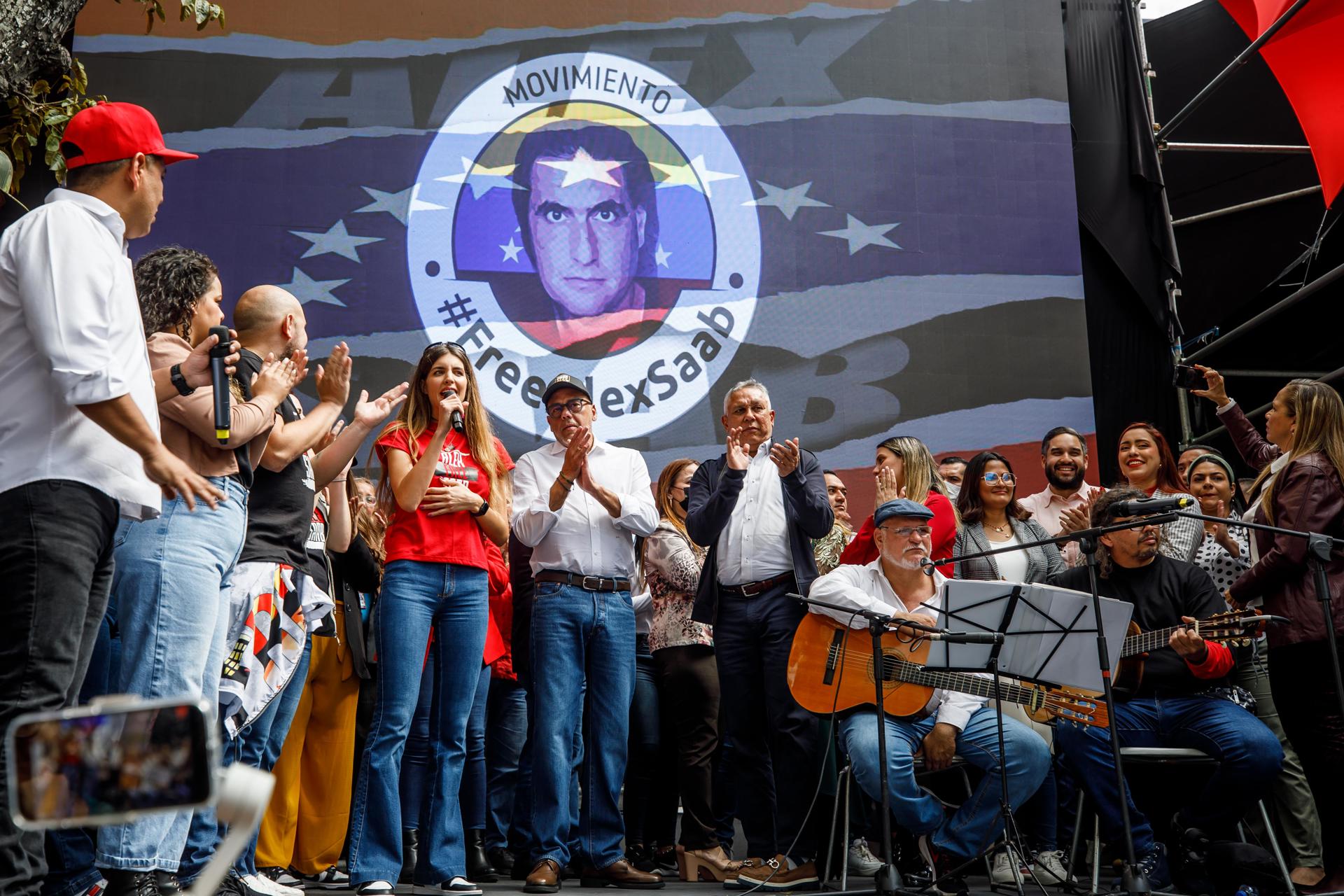 Camila Fabri (camisa roja), esposa de Alex Saab y el presidente de la Asamblea Nacional de Venezuela, Jorge Rodriguez (c), participan en una concentración en apoyo a Alex Saab en Caracas (Venezuela). EFE/ Miguel Gutiérrez
