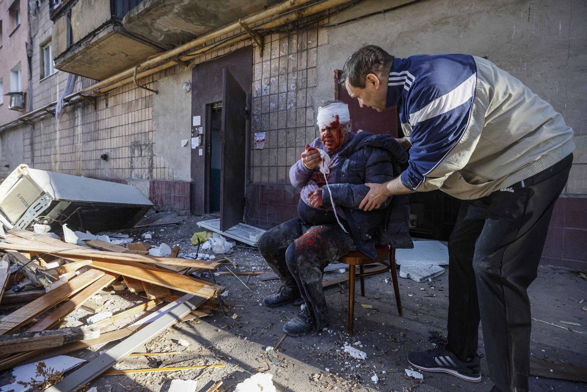 Un herido recibe ayuda de un vecino después de que el edificio en el que reside fuera atacado por un misil ruso en Donetsk, Ucrania. EFE/ Sergei Ilnitsky
