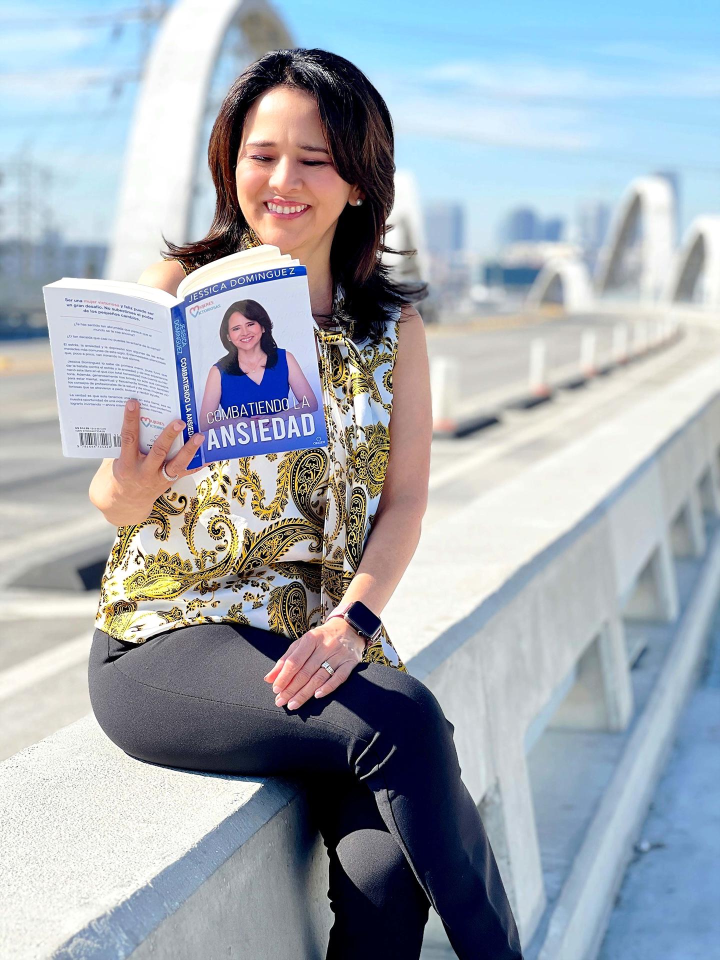 Fotografía personal cedida donde aparece la abogada peruana Jessica Domínguez mientras posa hojeando su nuevo libro 