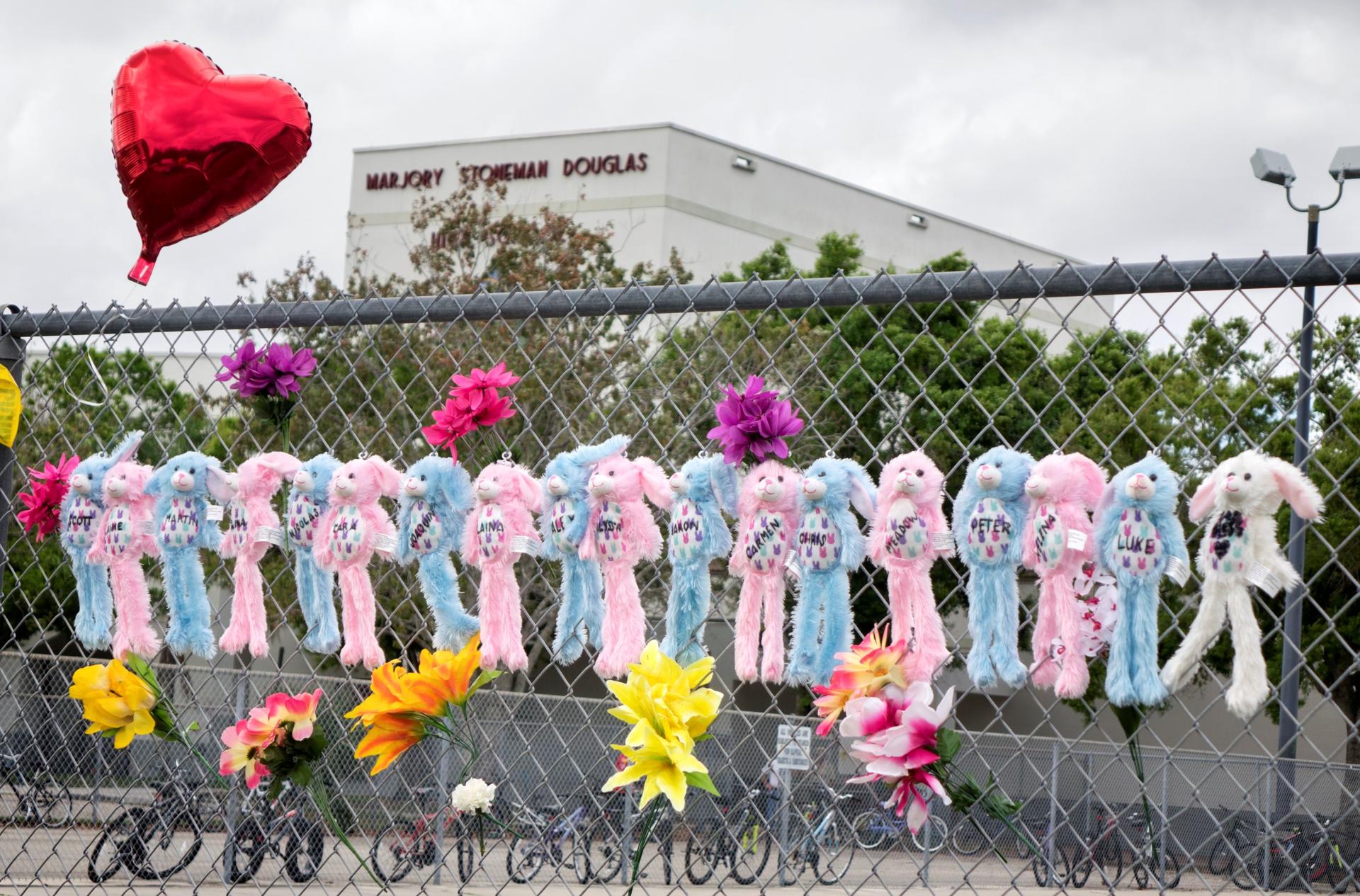 Fotografía de archivo de varias personas que depositan flores y juguetes en un monumento a las víctimas del tiroteo en el instituto de Parkland, Florida, (Estados Unidos). EFE/ Cristobal Herrera
