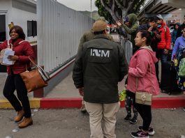 Grupos de personas migrantes hacen fila para cruzar a Estados Unidos y continuar con su proceso de asilo a través de la garita internacional del Chaparral ayer, en Tijuana, Baja California (México). EFE/ Joebeth Terríquez
