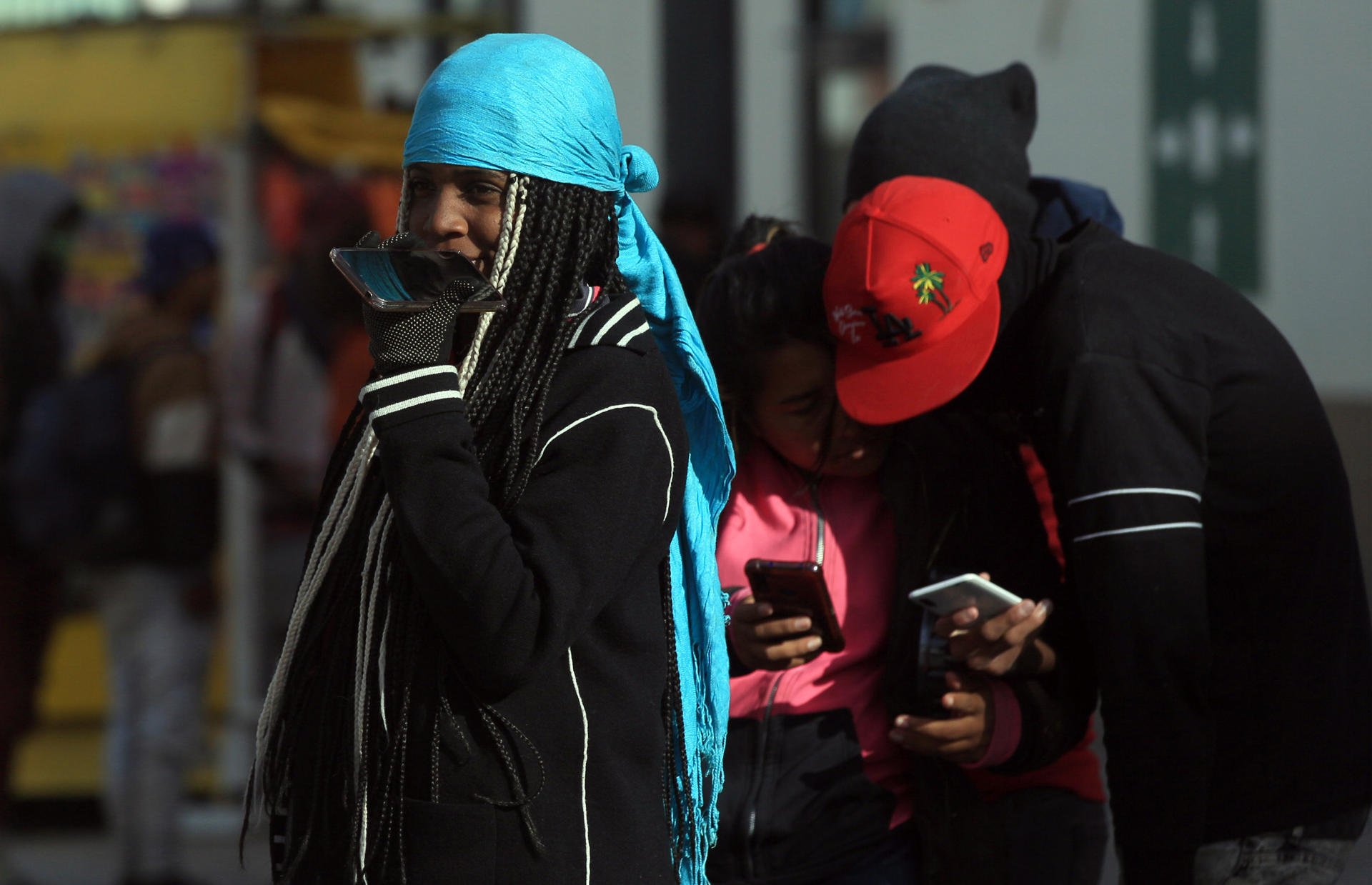 Fotografía de migrantes usando sus teléfonos móviles, el 18 de febrero de 2023, en Ciudad Juárez, Chihuahua (México). EFE/Luis Torres
