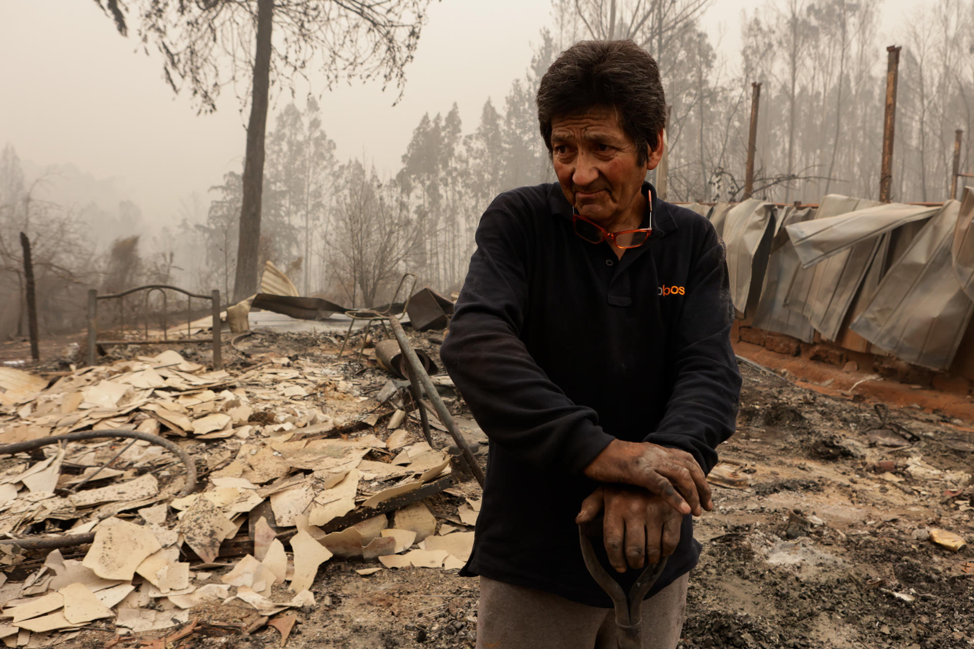 Un hombre se posa sobre escombros y destrozos ocasionados por un incendio hoy, en Santa Juana, Región del Biobío (Chile). EFE/ Esteban Paredes Drake
