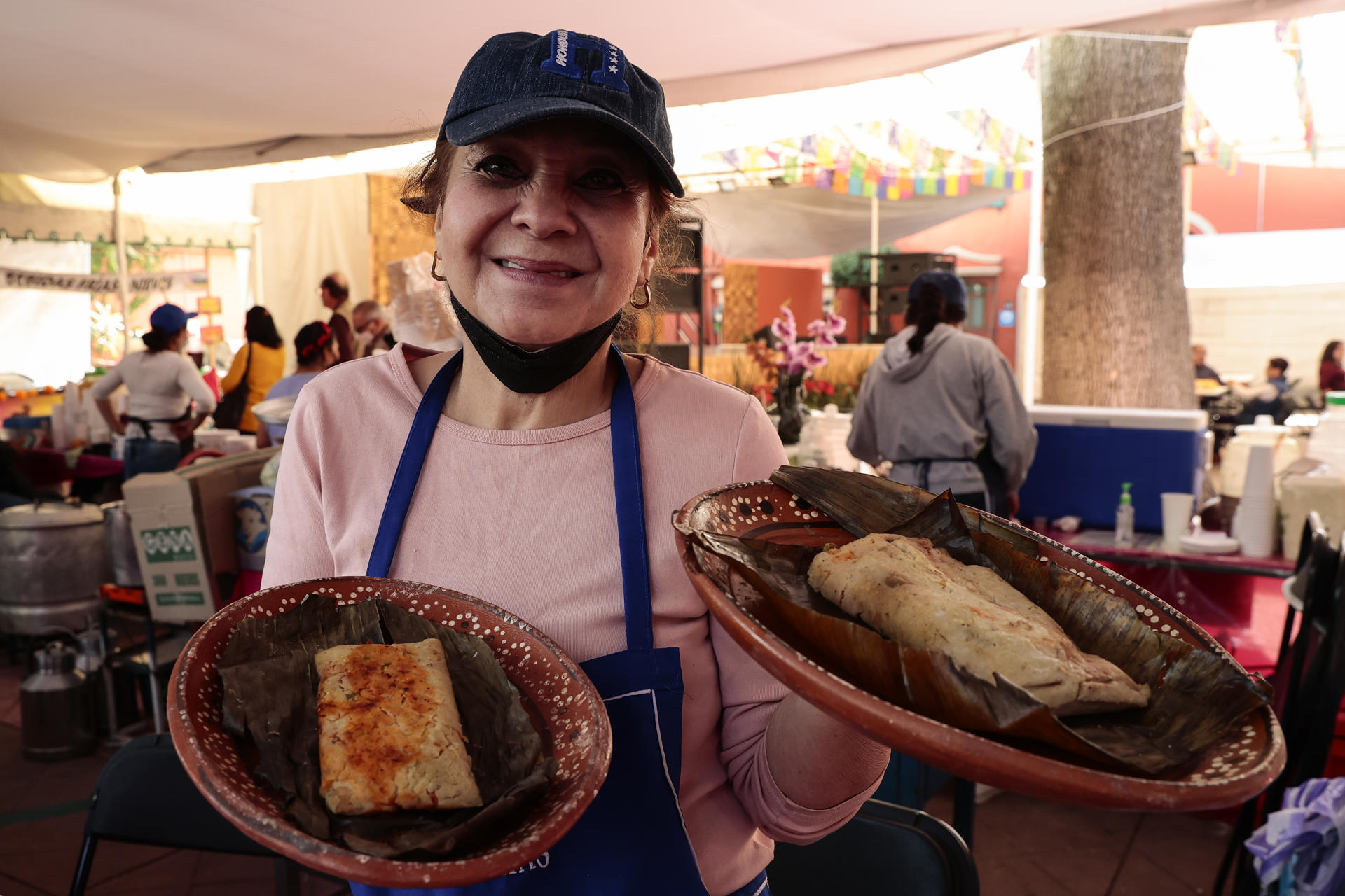 La hondureña Mundy Rodríguez muestra unas variedades de tamal de su país durante la Feria del Tamal de la alcaldía Coyoacán, durante la celebración del Día de la Candelaria, el 30 de enero de 2023, en Ciudad de México. (México). EFE/ José Méndez
