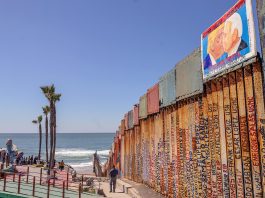 Vista de una imagen del expresidente estadounidense Donald Trump besando al actual mandatario, Joe Biden (d), el 28 de marzo de 2023 en el muro fronterizo en la ciudad de Tijuana en Baja California (México). EFE/Joebeth Terriquez

