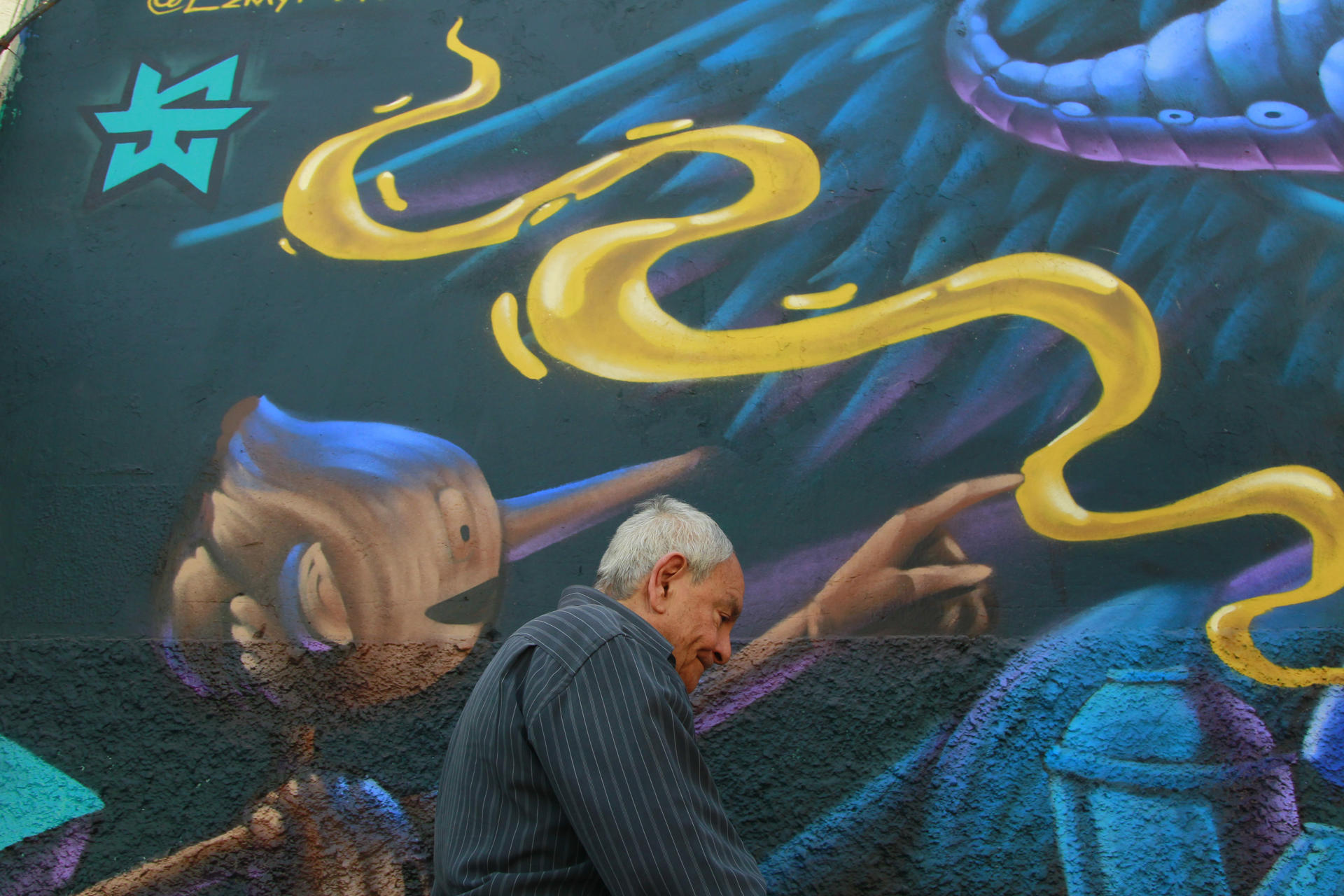 Un hombre camina junto a un mural inspirado en la película 