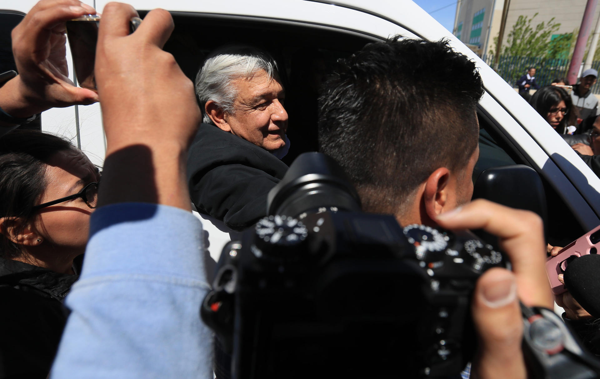 Un grupo de migrantes y activistas protestan durante la llegada del presidente de México Andrés Manuel López Obrador, hoy a Ciudad Juárez, en el estado de Chihuahua (México). EFE/ Luis Torres
