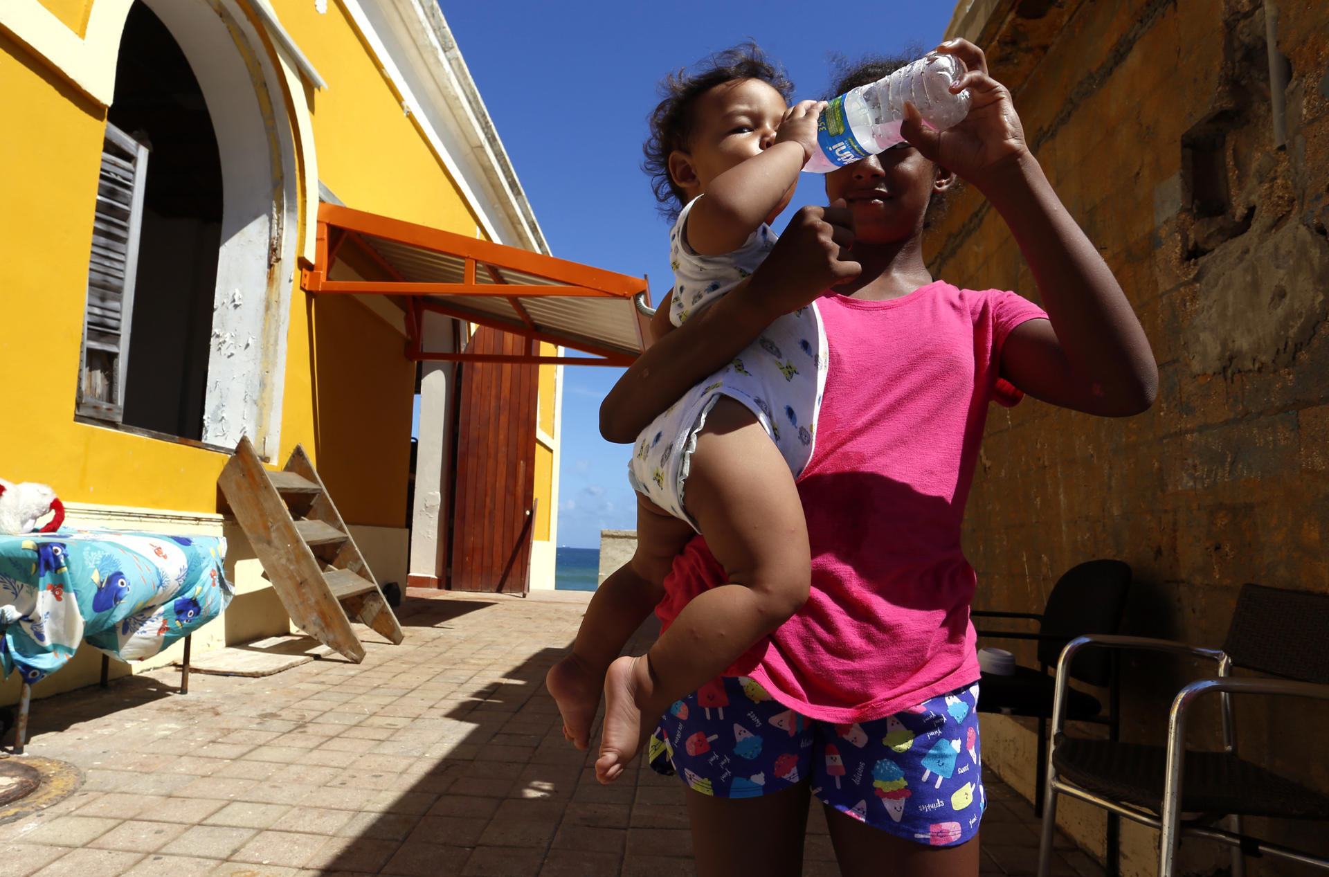 Fotografía de archivo de una mujer que le da agua a su bebé en San Juan, Puerto Rico. EFE/Thais Llorca
