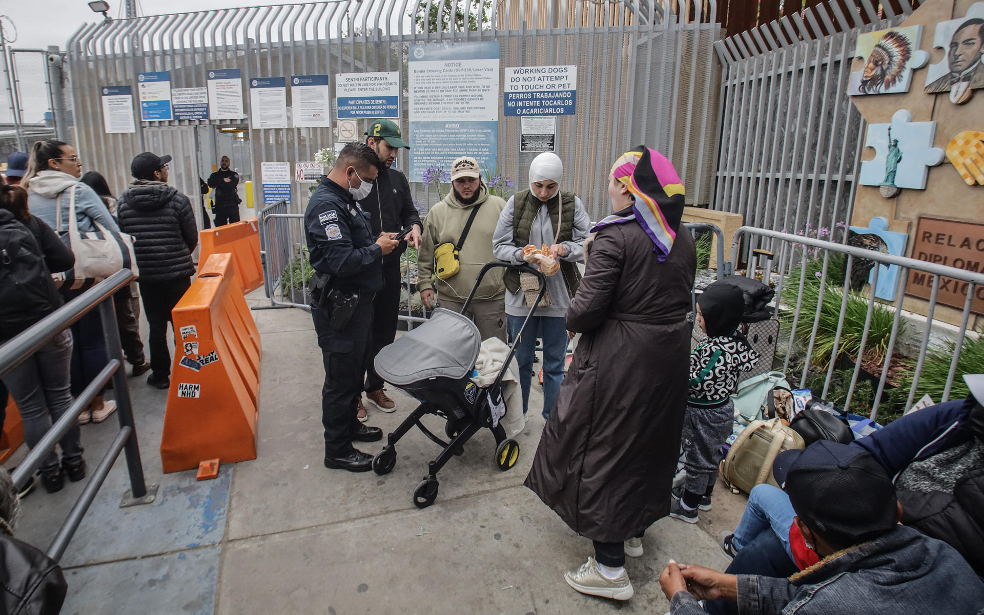 Migrantes de diferentes nacionalidades esperan en la entrada de la garita peatonal de San Ysidro para solicitar asilo a las autoridades estadounidenses, el 29 de mayo de 2023, en Tijuana (México). EFE/Joebeth Terríquez
